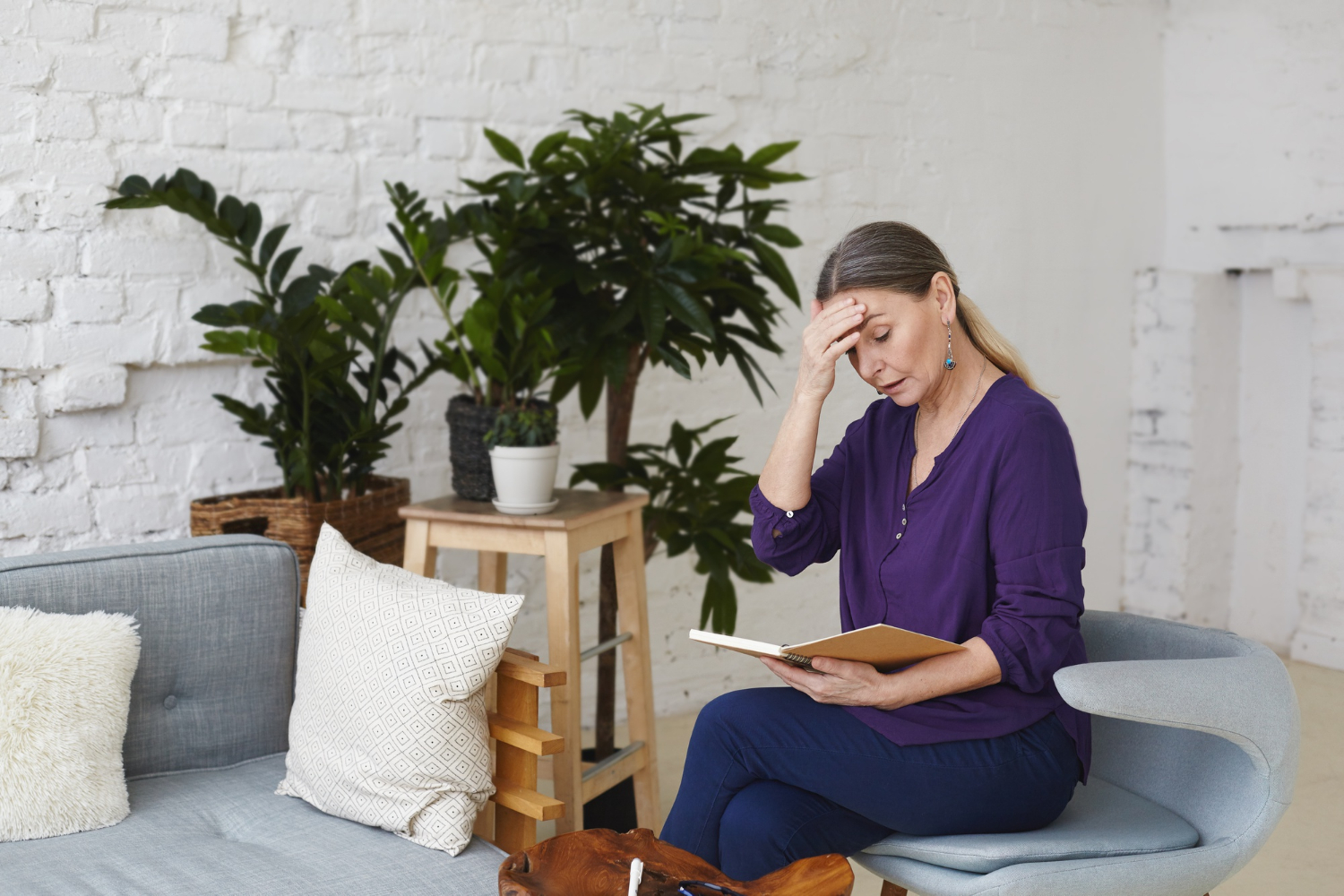 A disheartened senior woman holding a book | Source: Freepik