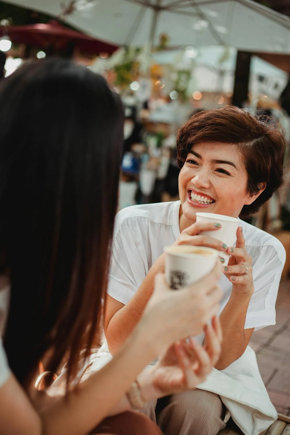 A woman smiling at her friend in a cafe | Source: Pexels