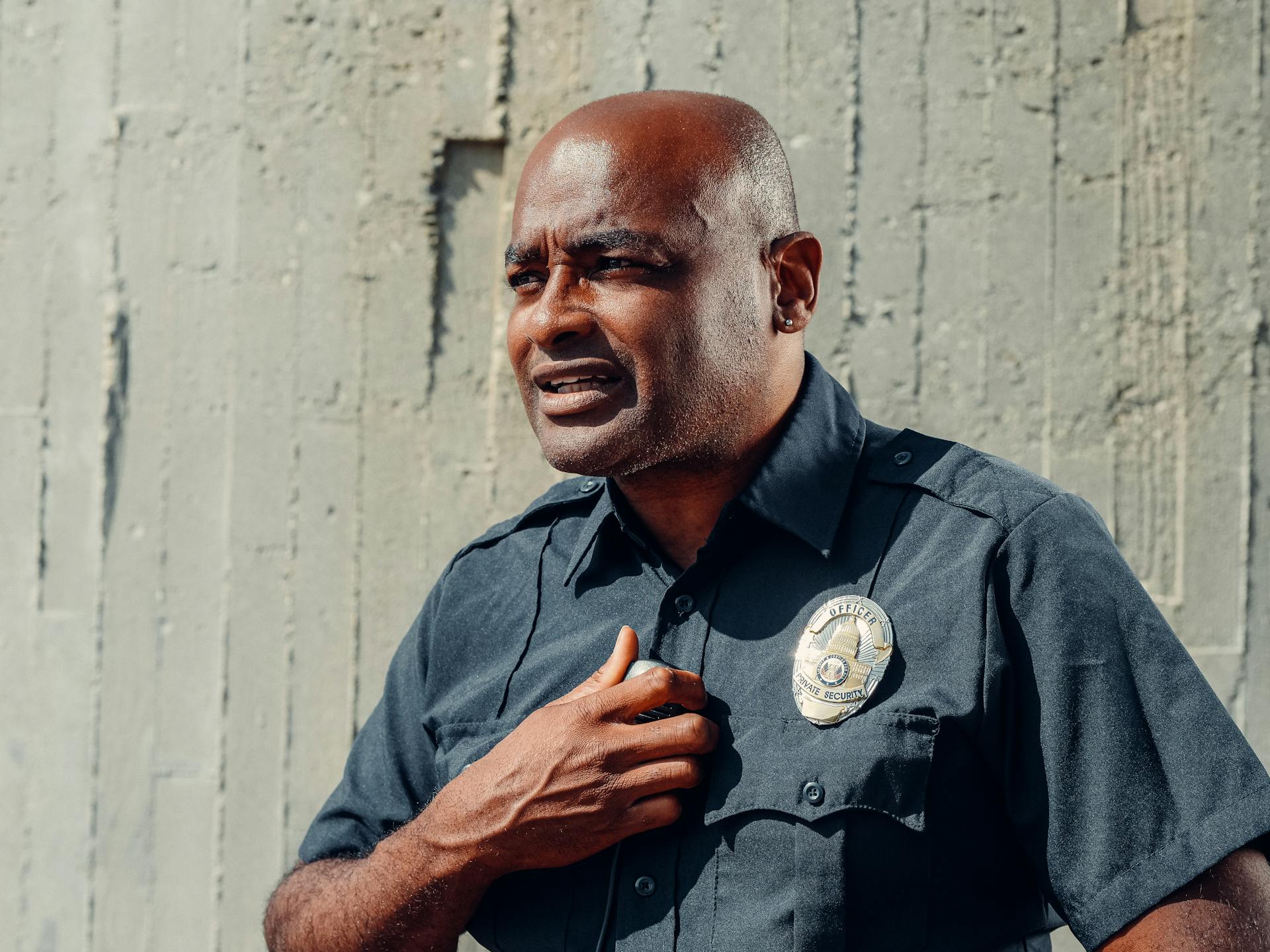 A police officer standing beside a gray concrete wall | Source: Pexels