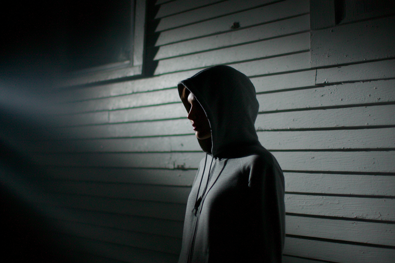 A person standing near a house at night | Source: Midjourney