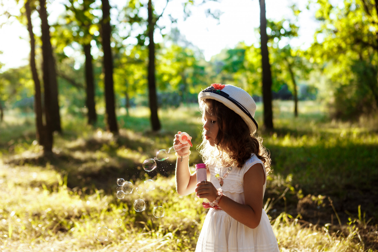 A little girl blowing soap bubbles | Source: Freepik