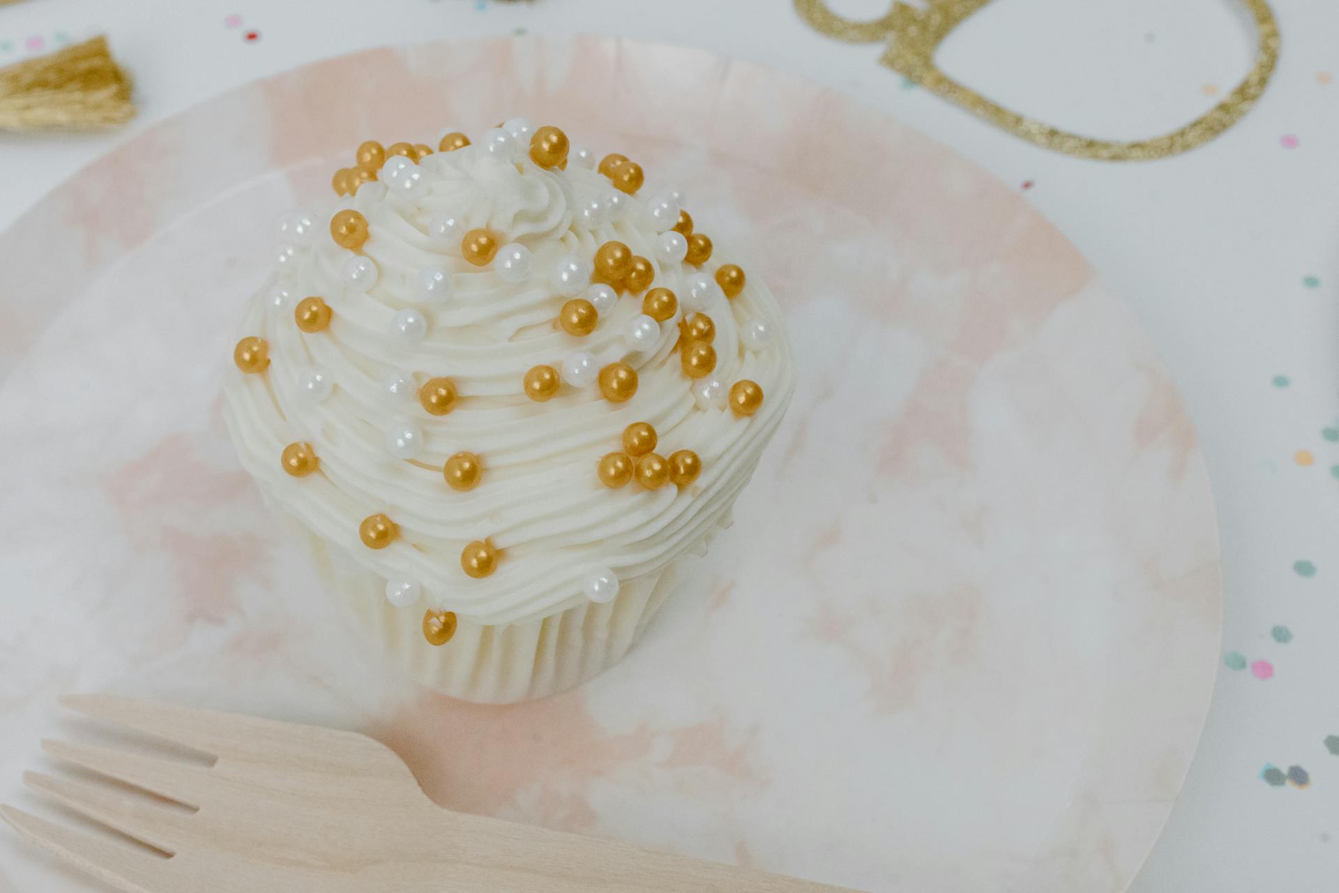 A cupcake with gold and white pearls | Source: Pexels