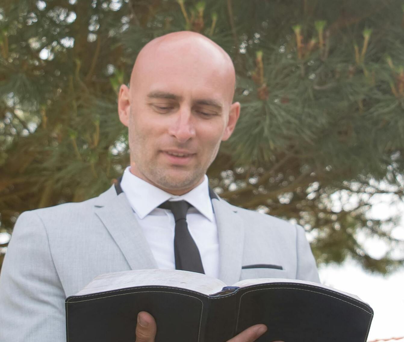 A man, acting as a wedding officiant, reading a book | Source: Pexels