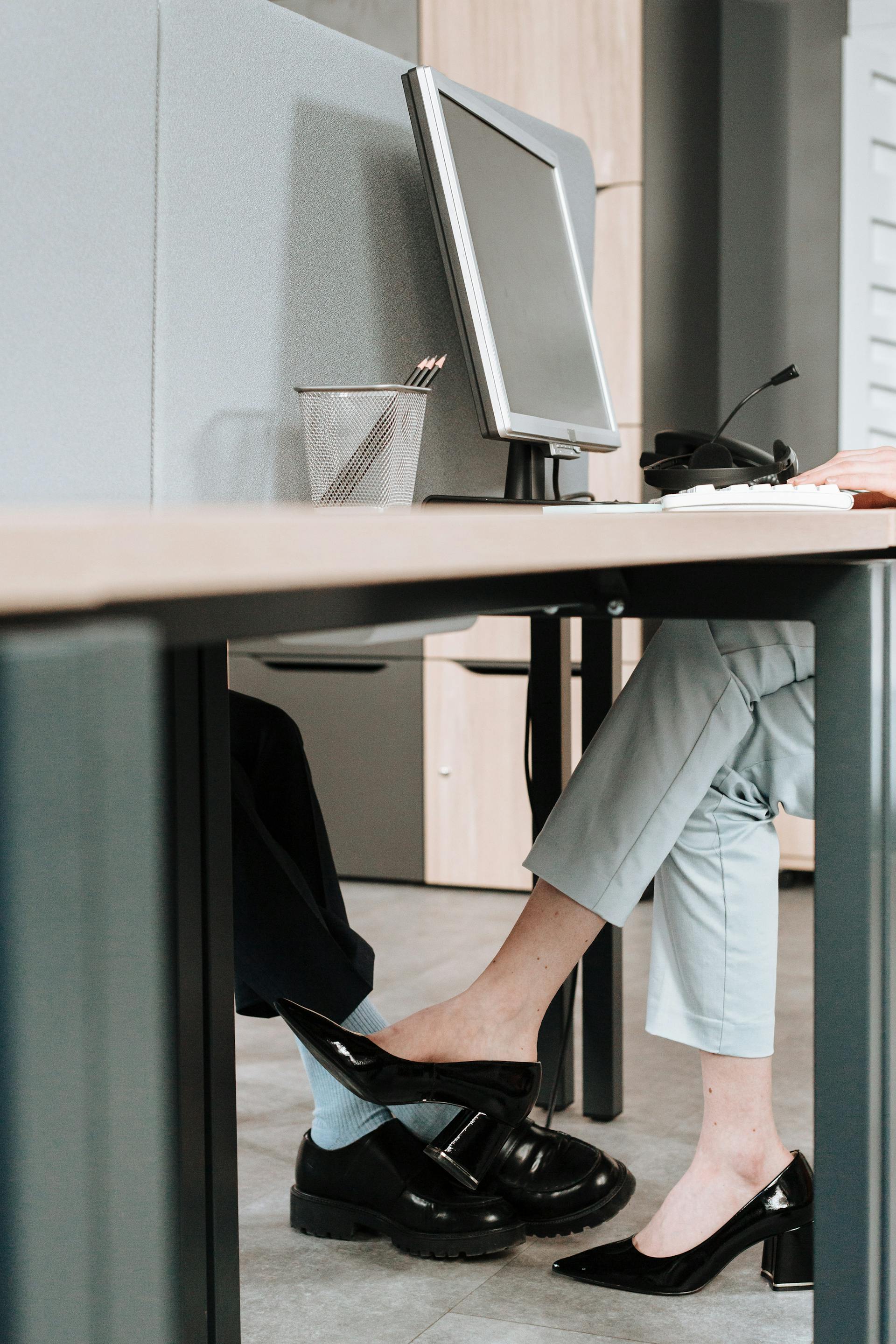 A close-up shot of colleagues flirting under the desk | Source: Pexels