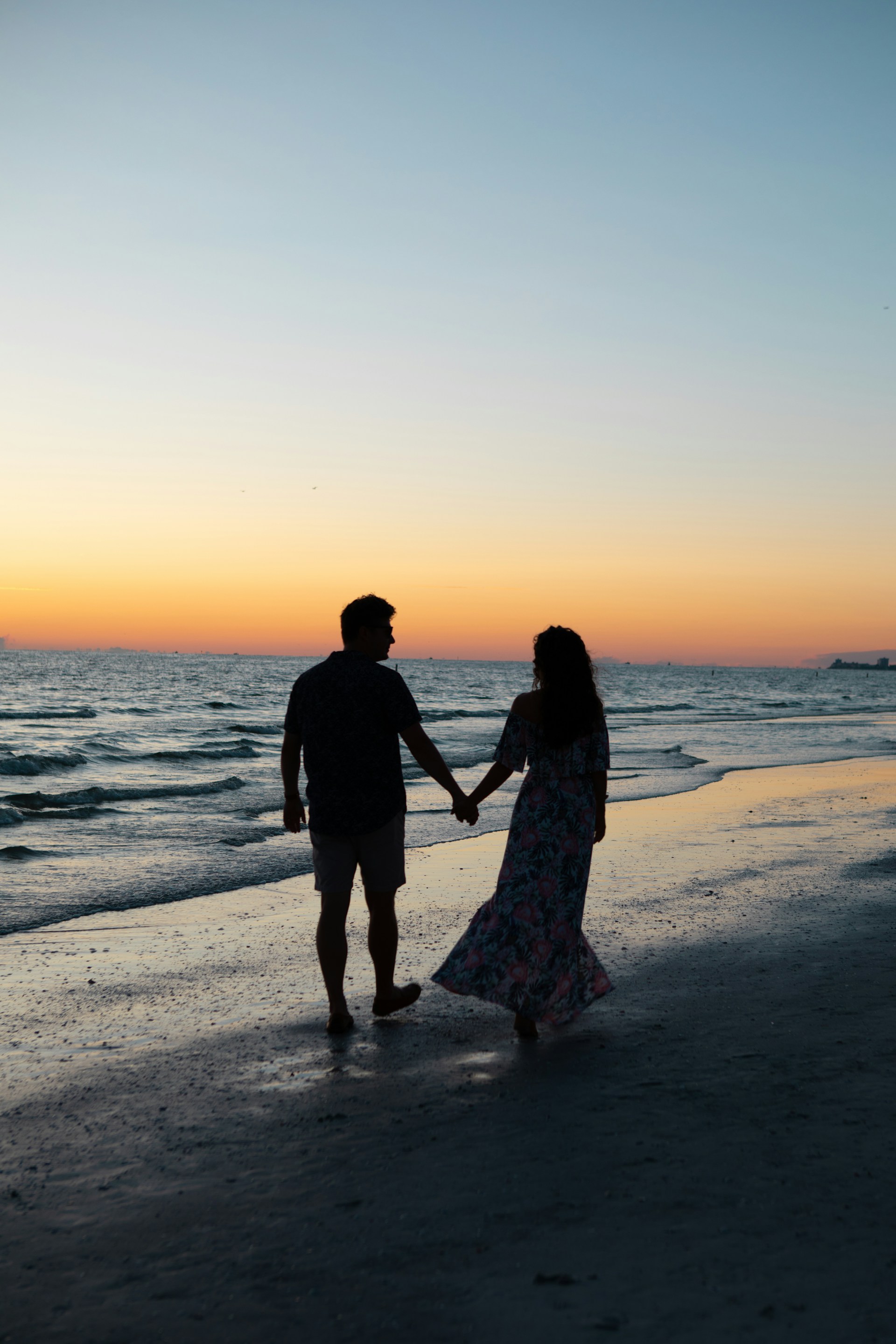 A young romantic couple walking on the beach on a beautiful evening | Source: Unsplash