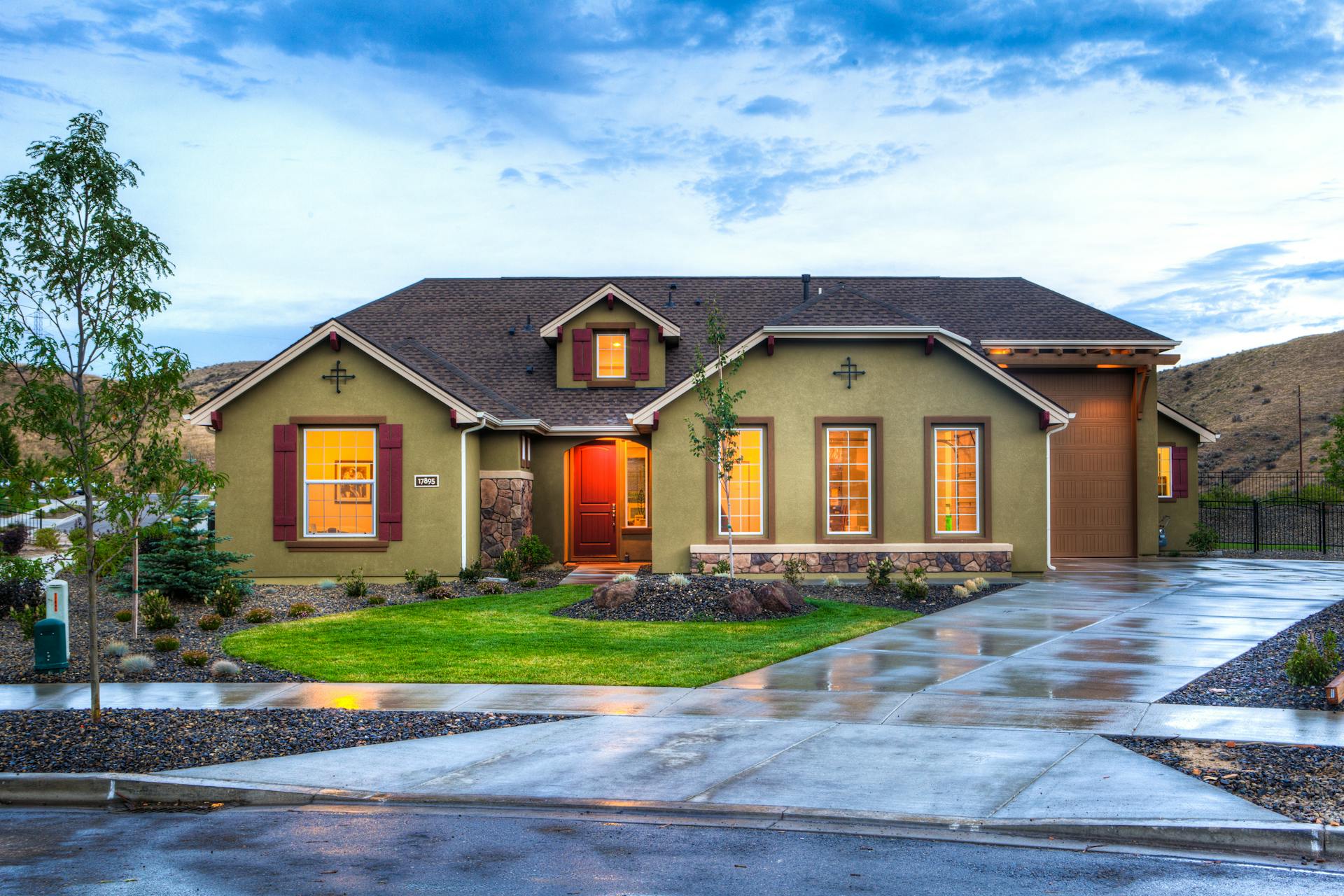 A house with its lights on and a wet driveway | Source: Pexels