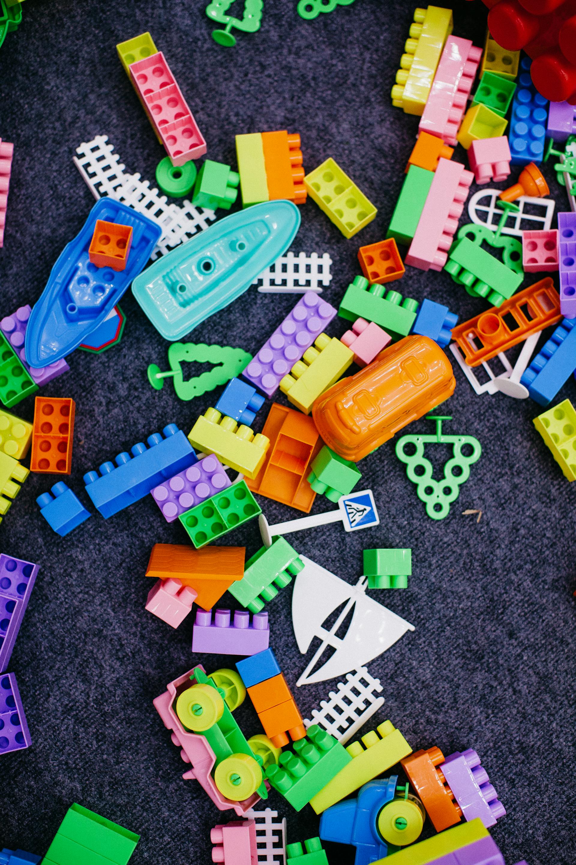 Gros plan de blocs de jouets éparpillés sur le sol | Source : Pexels