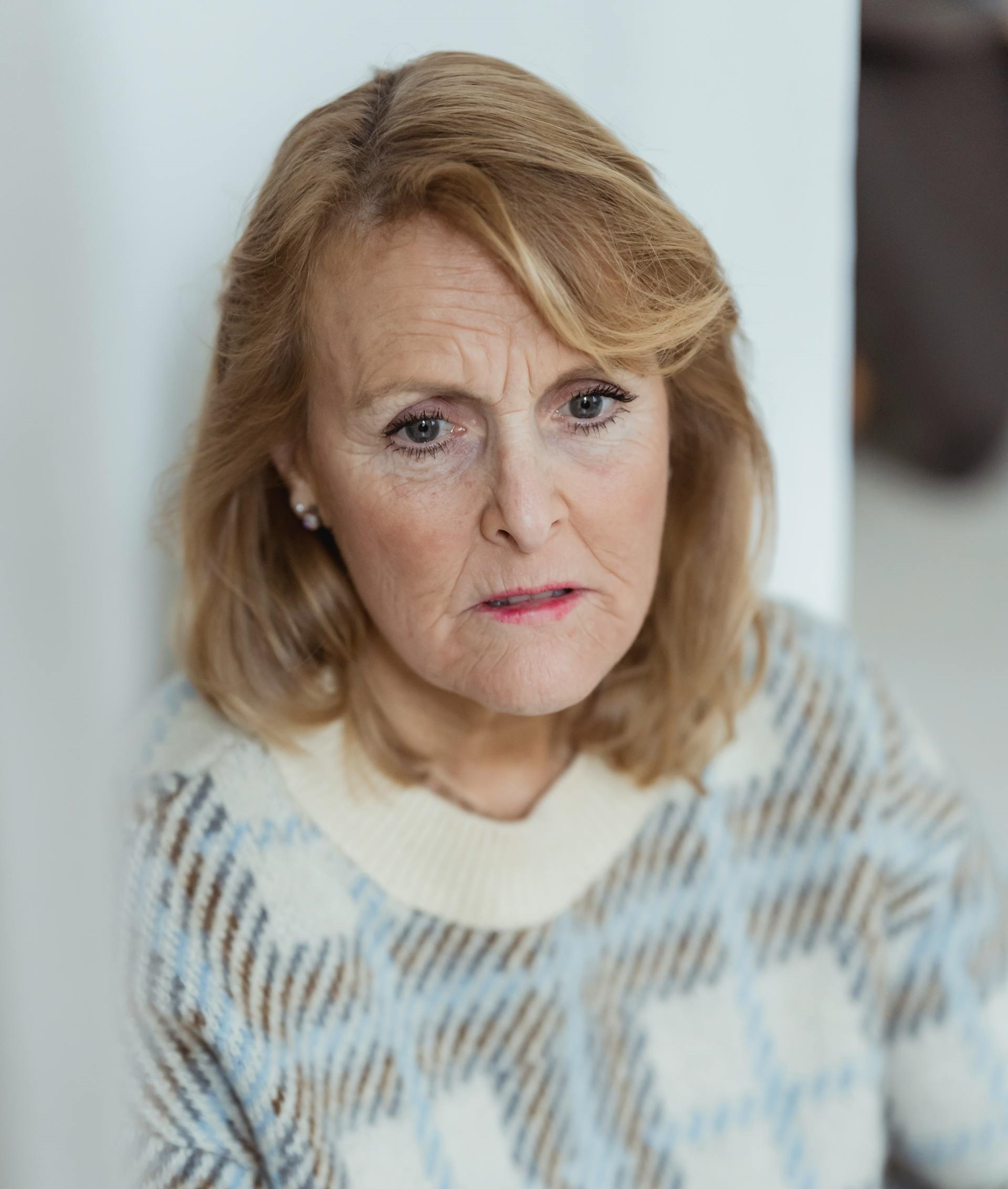 A sad mature woman in a plaid sweater with a frown on her face | Source: Pexels