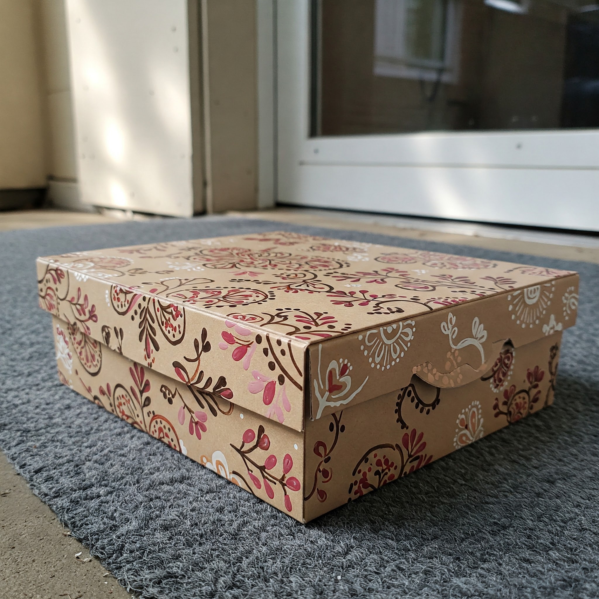 A beautifully decorated box lying outside an apartment door | Source: Gemini