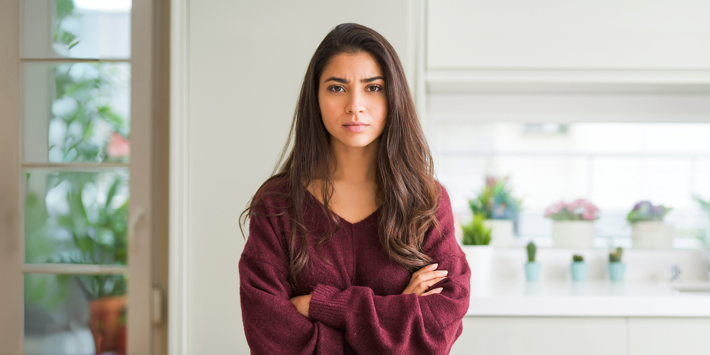 An annoyed-looking woman standing with her arms crossed | Source: Shutterstock