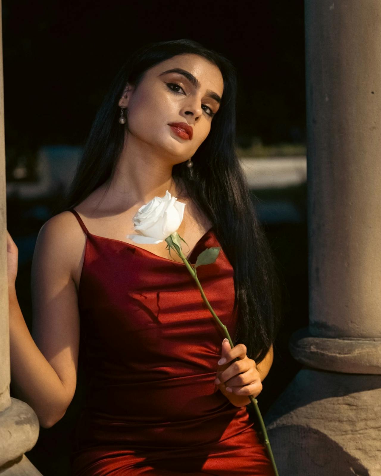 A woman in a red dress holding a rose | Source: Pexels