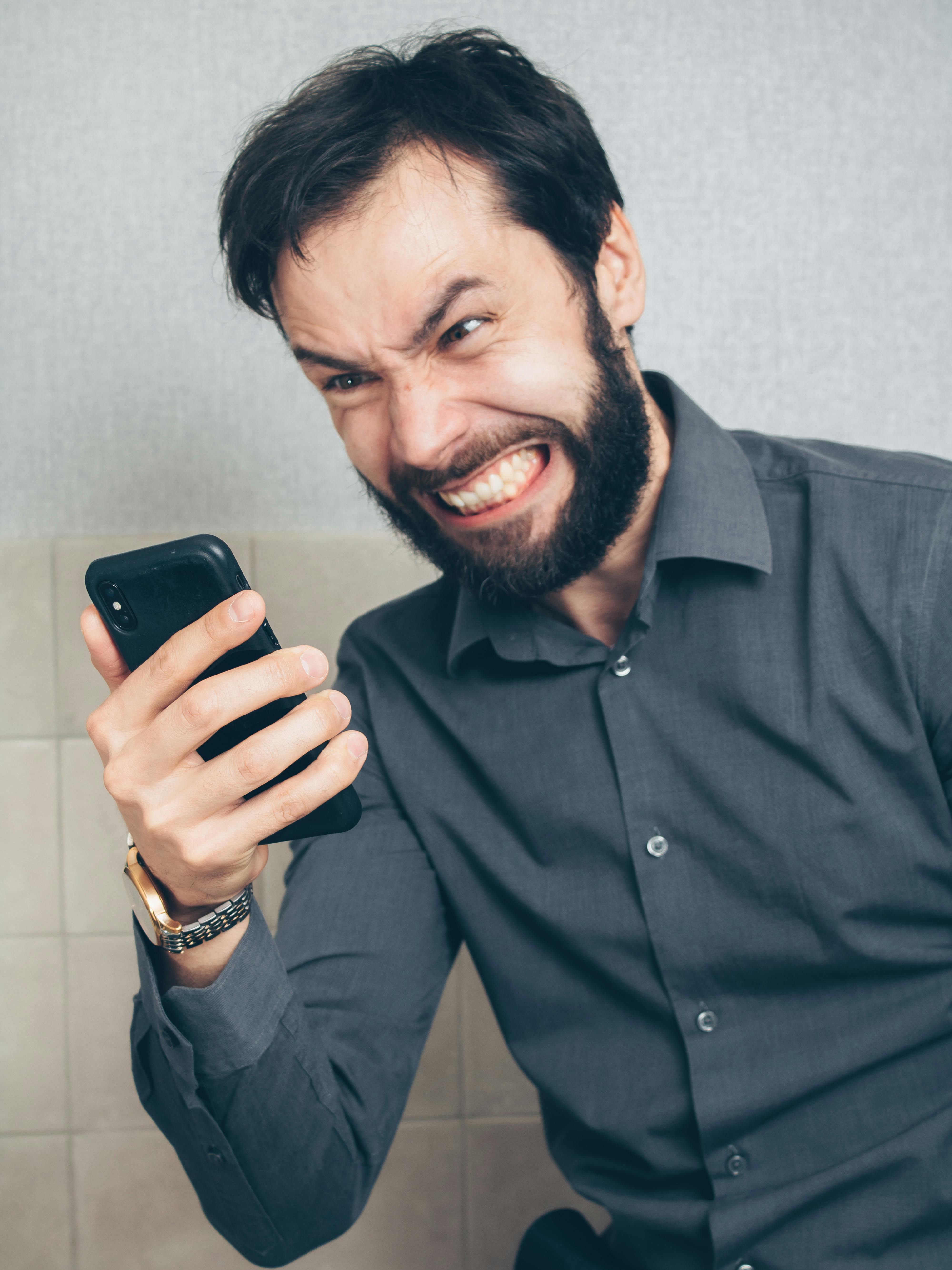 An angry man looking at a phone | Source: Pexels