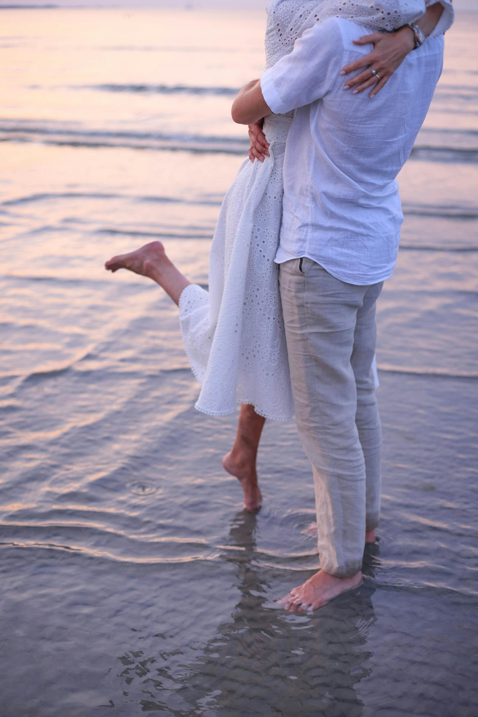 A close-up shot of a couple hugging on the beach | Source: Pexels