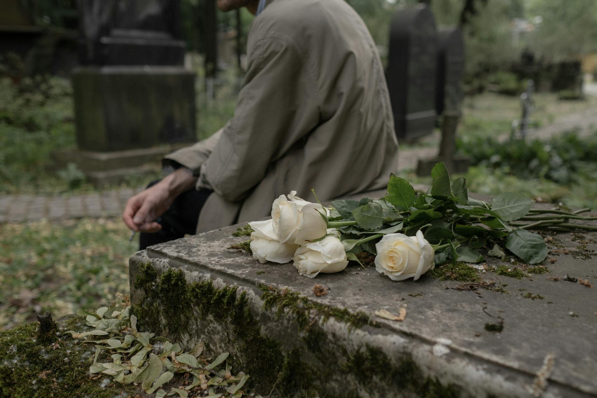 A man seated by a grave | Source: Pexels