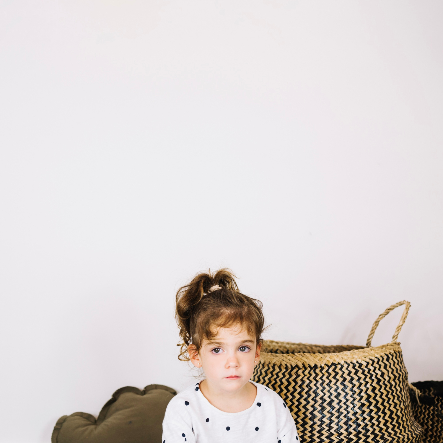 A sad little girl sitting near a basket | Source: Freepik