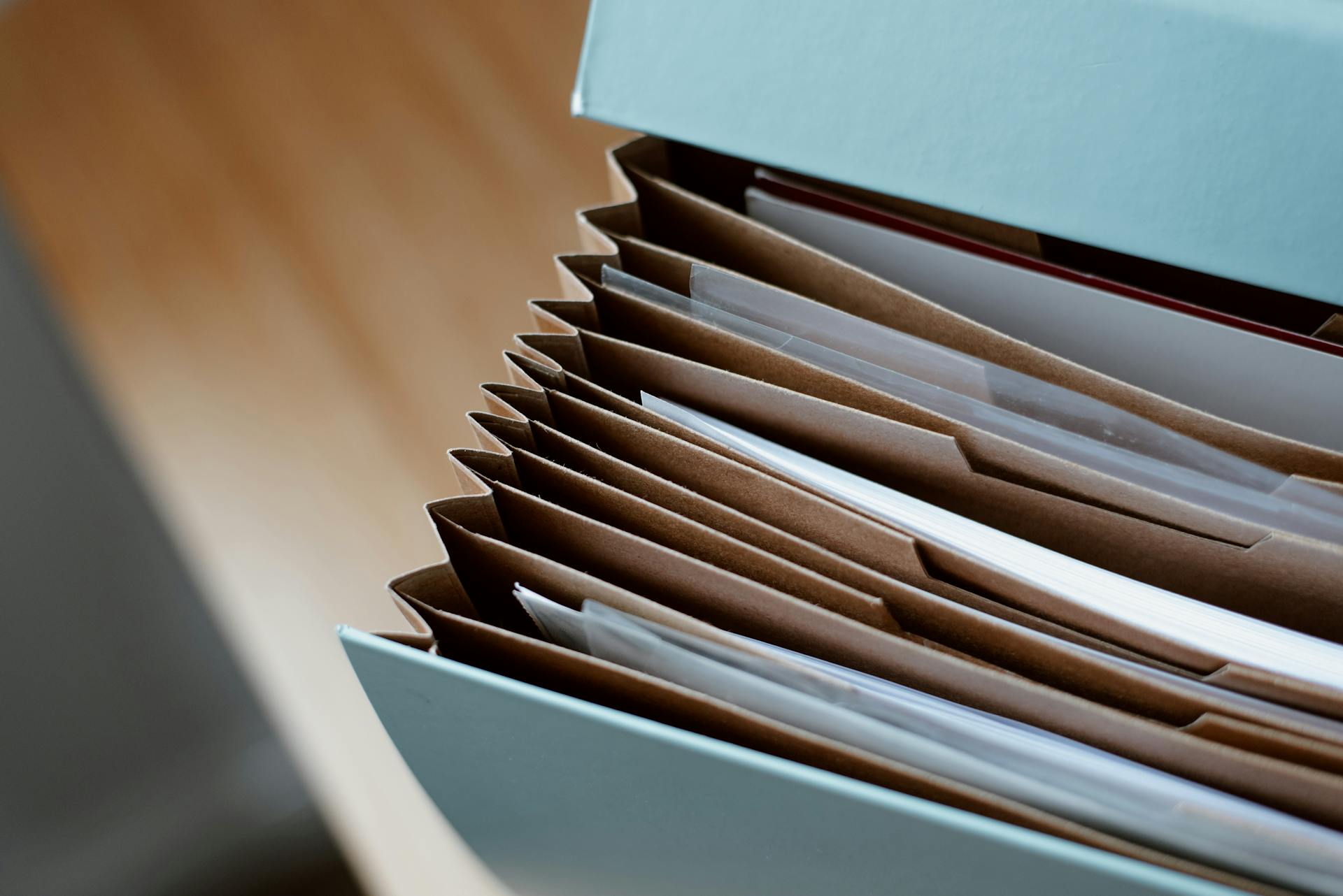 A blue accordion folder with multiple paper files inside | Source: Pexels