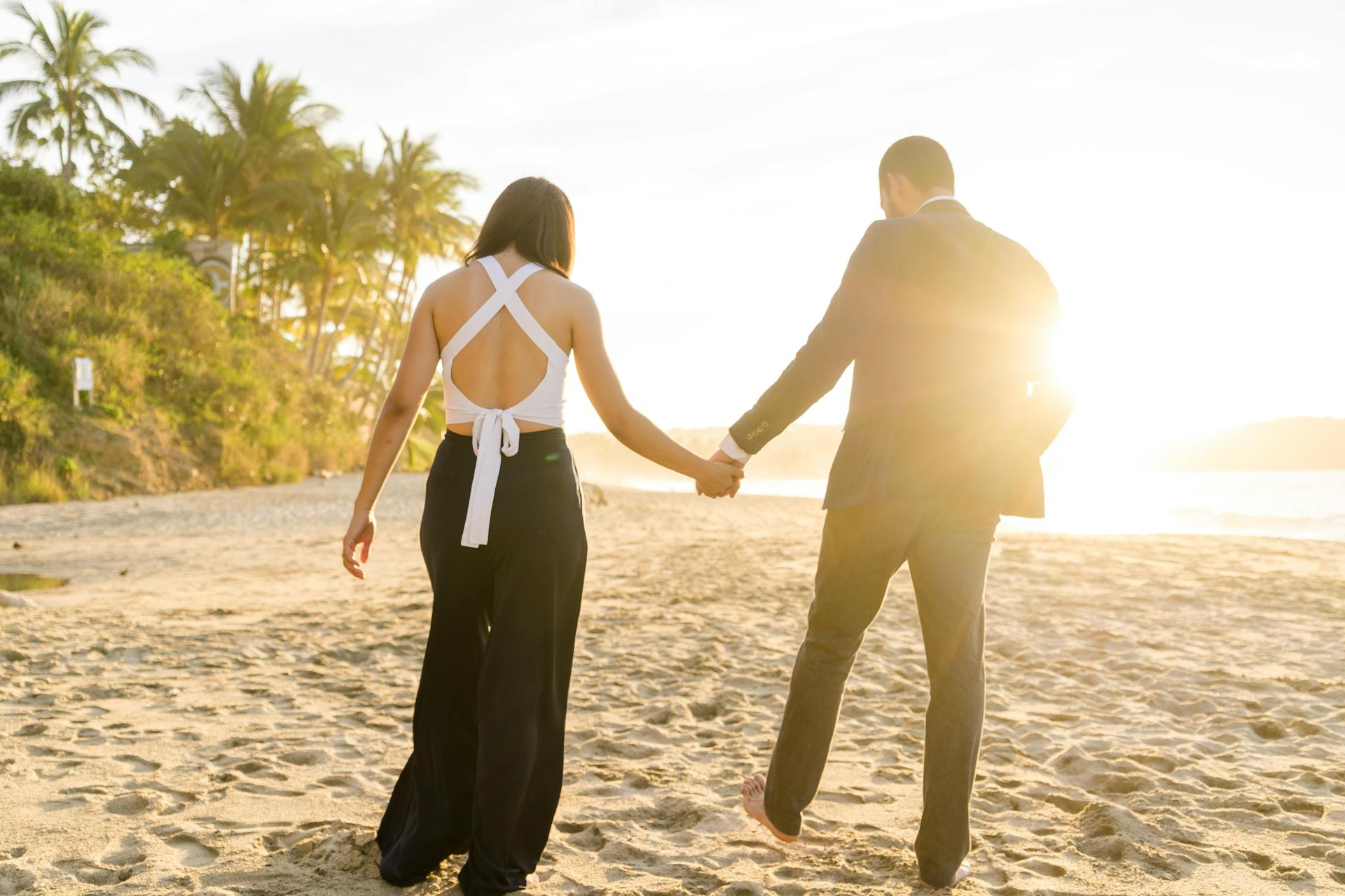 Rear view of a couple walking on the beach | Source: Pexels