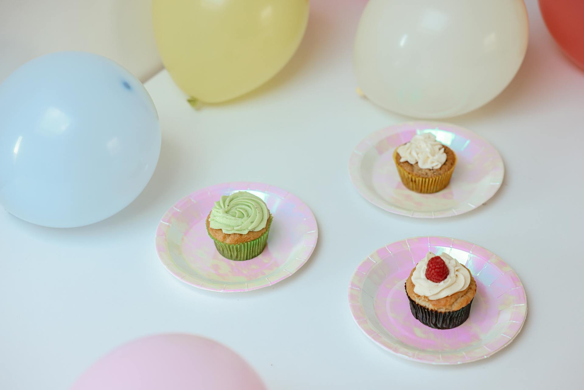 Cupcakes and colorful balloons on a table | Source: Pexels
