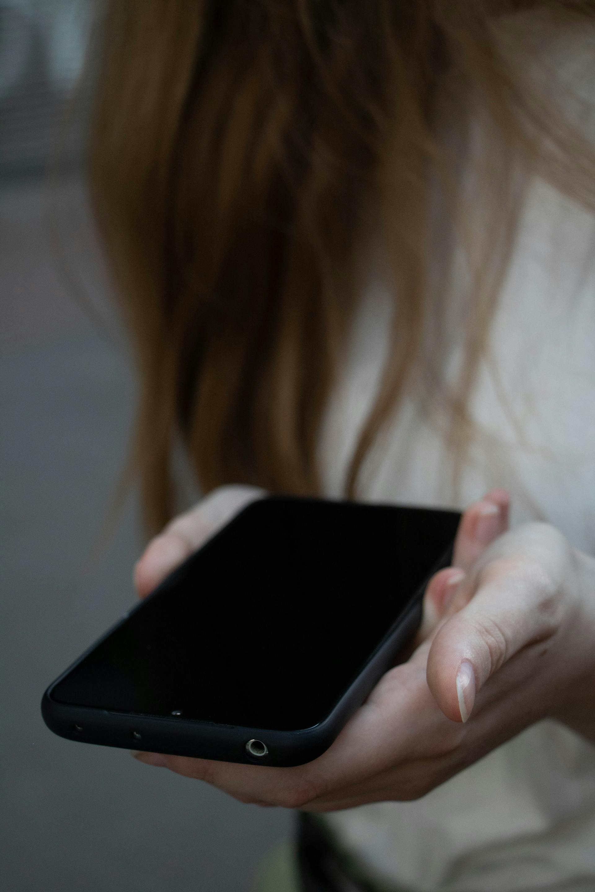 A woman holding her cell phone | Source: Pexels
