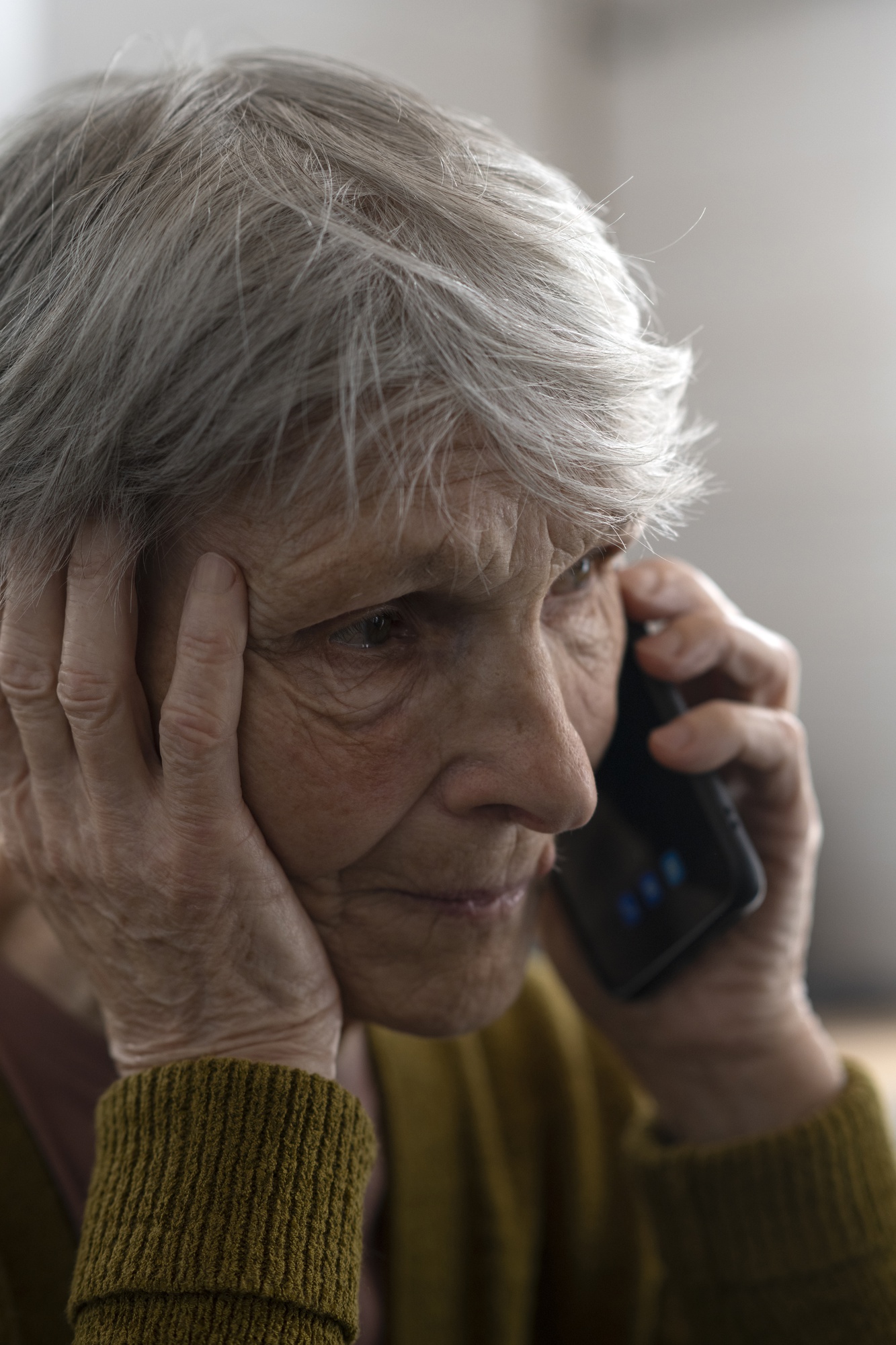 A sad elderly woman on her phone | Source: Freepik