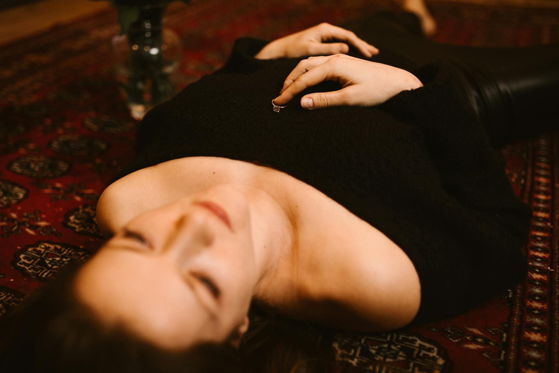 A woman lying on the floor with a ring on her chest | Source: Pexels