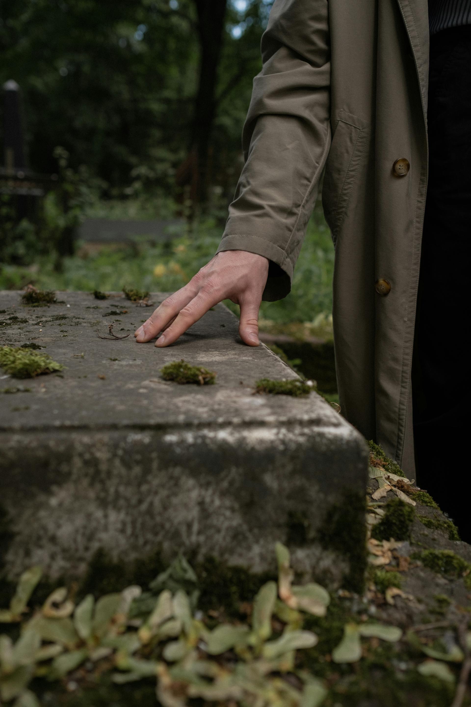 A person's hand on a tombstone | Source: Pexels