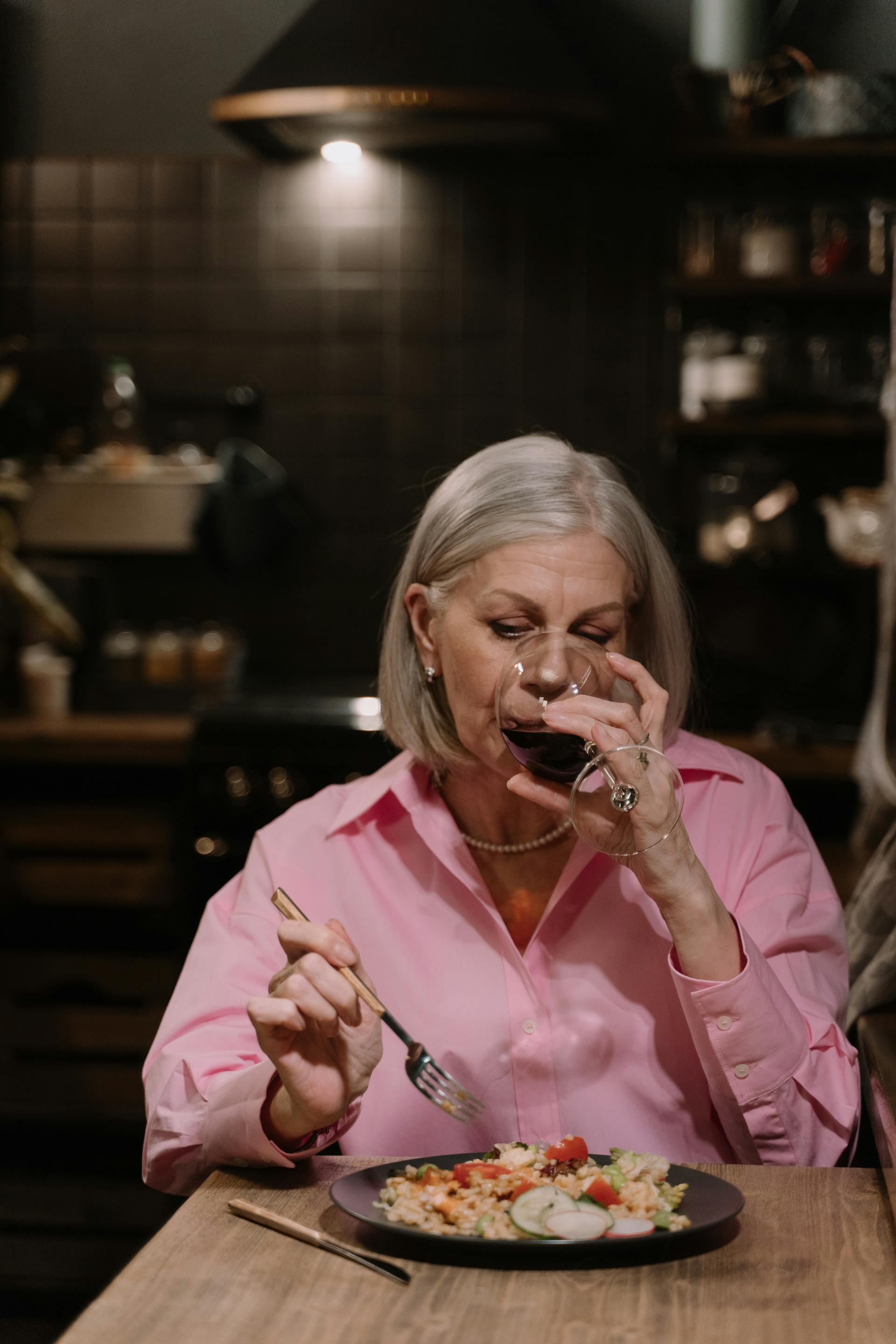 A senior woman drinking wine while having dinner | Source: Pexels