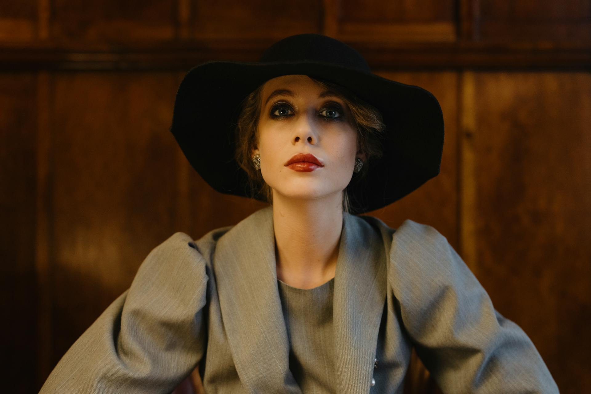 A serious woman in a gray jacket and a black hat looking forward | Source: Pexels