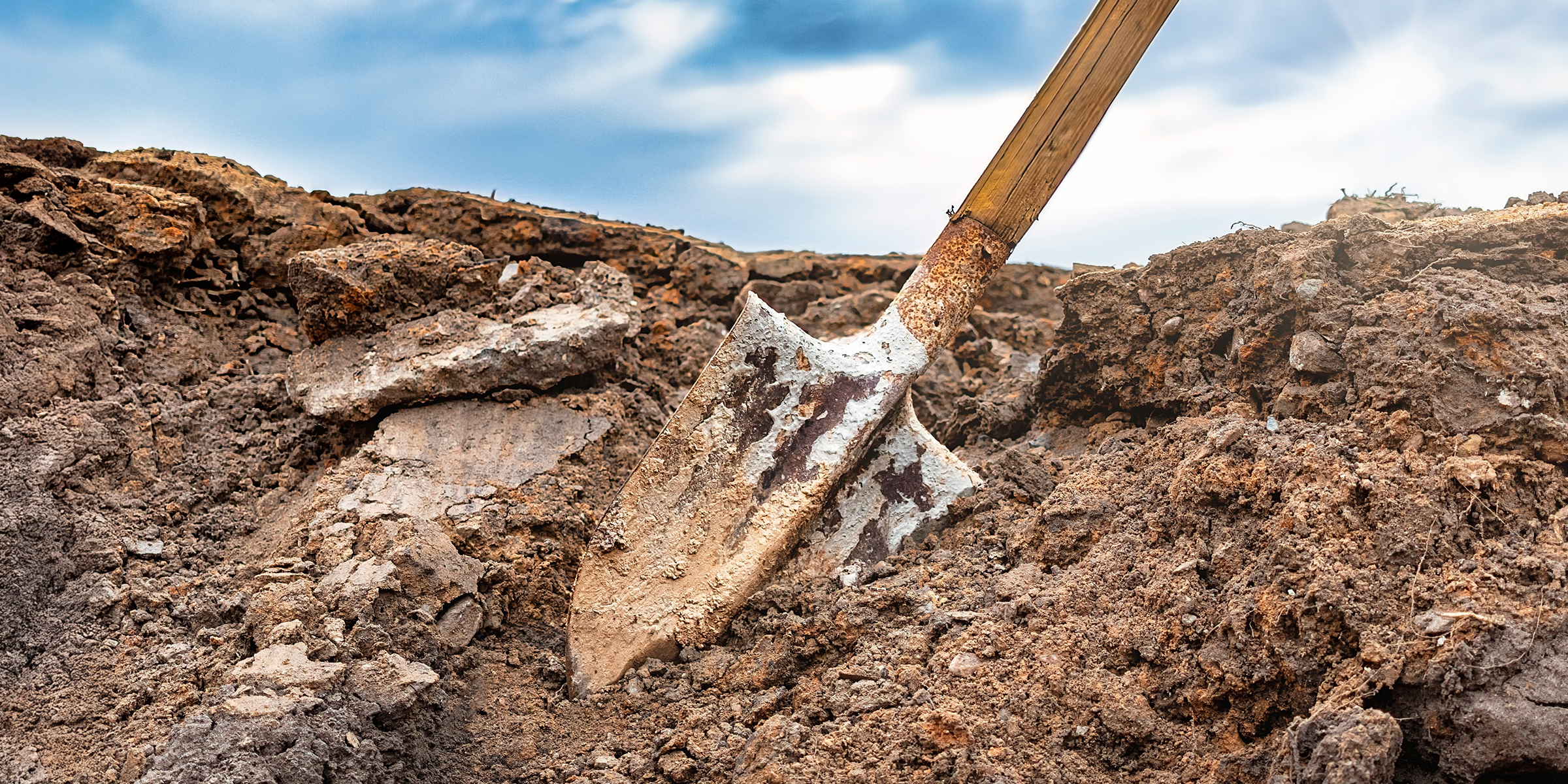 A dirty shovel in the ground | Source: Shutterstock