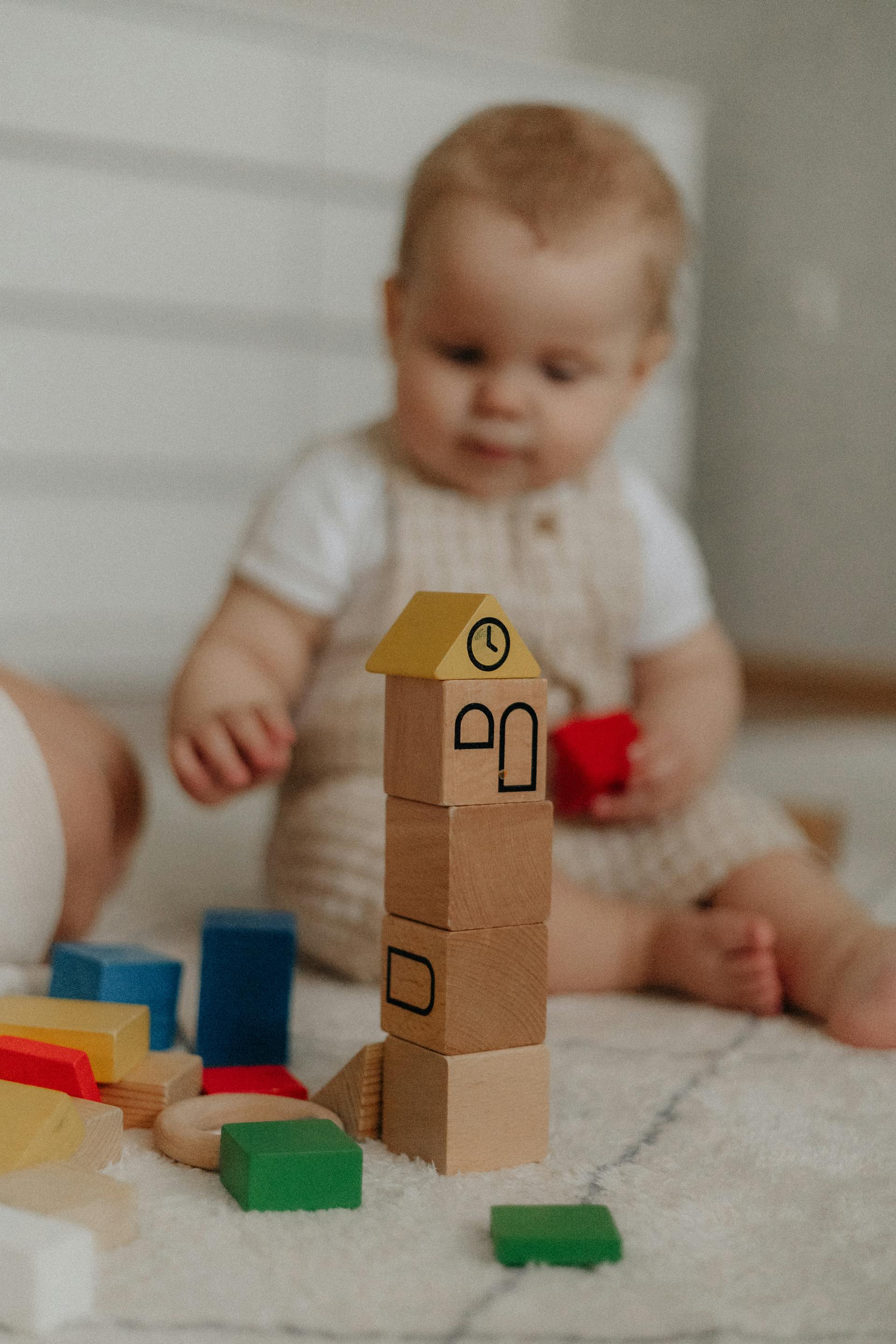 A baby sitting on the carpet and playing with blocks | Source: Pexels