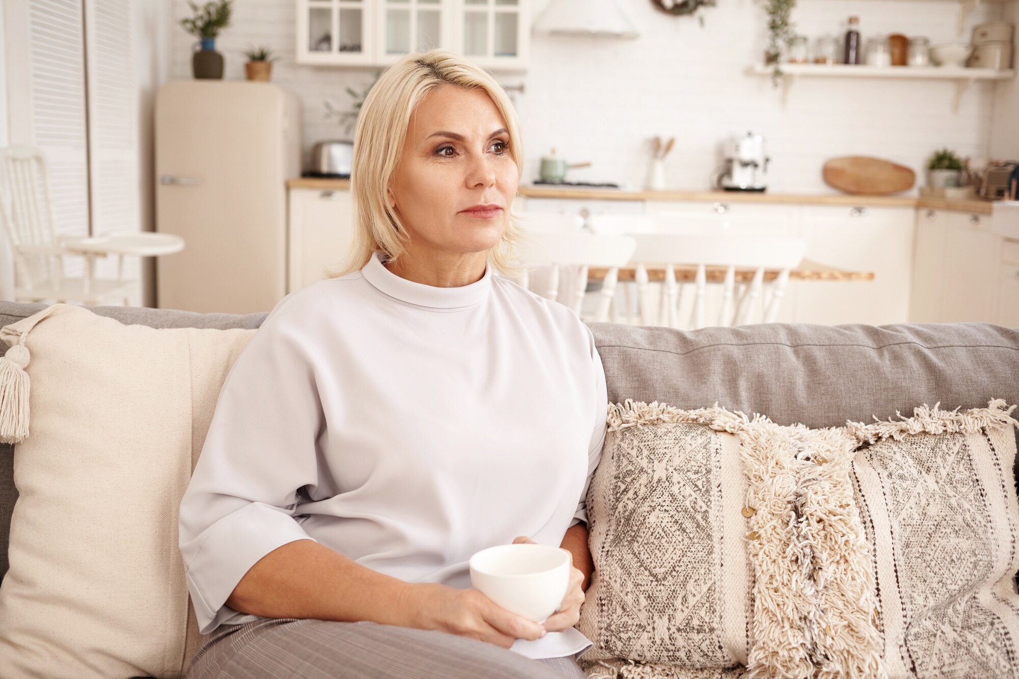 A woman with a serious expression sitting on a couch | Source: Freepik