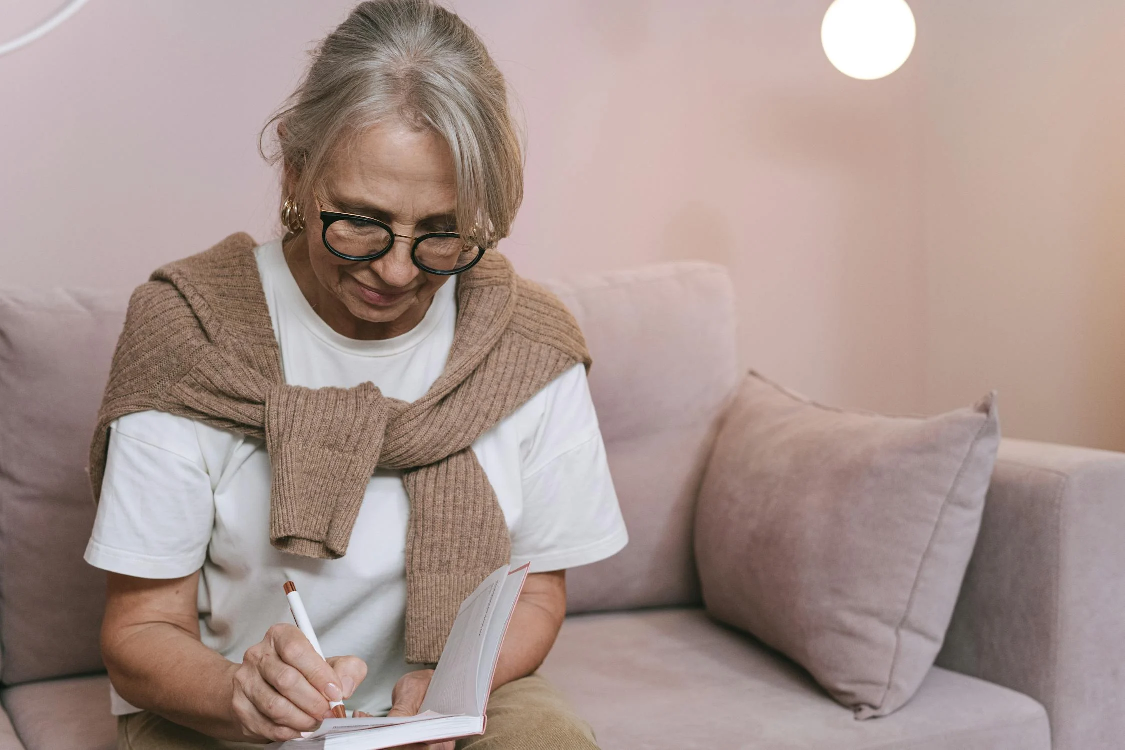 Uma mulher escrevendo em seu caderno | Fonte: Pexels