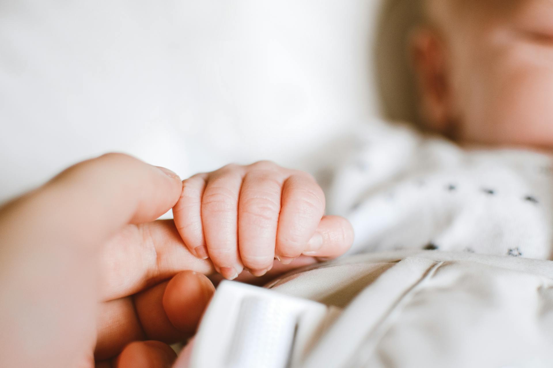 A baby holding a person's finger | Source: Pexels