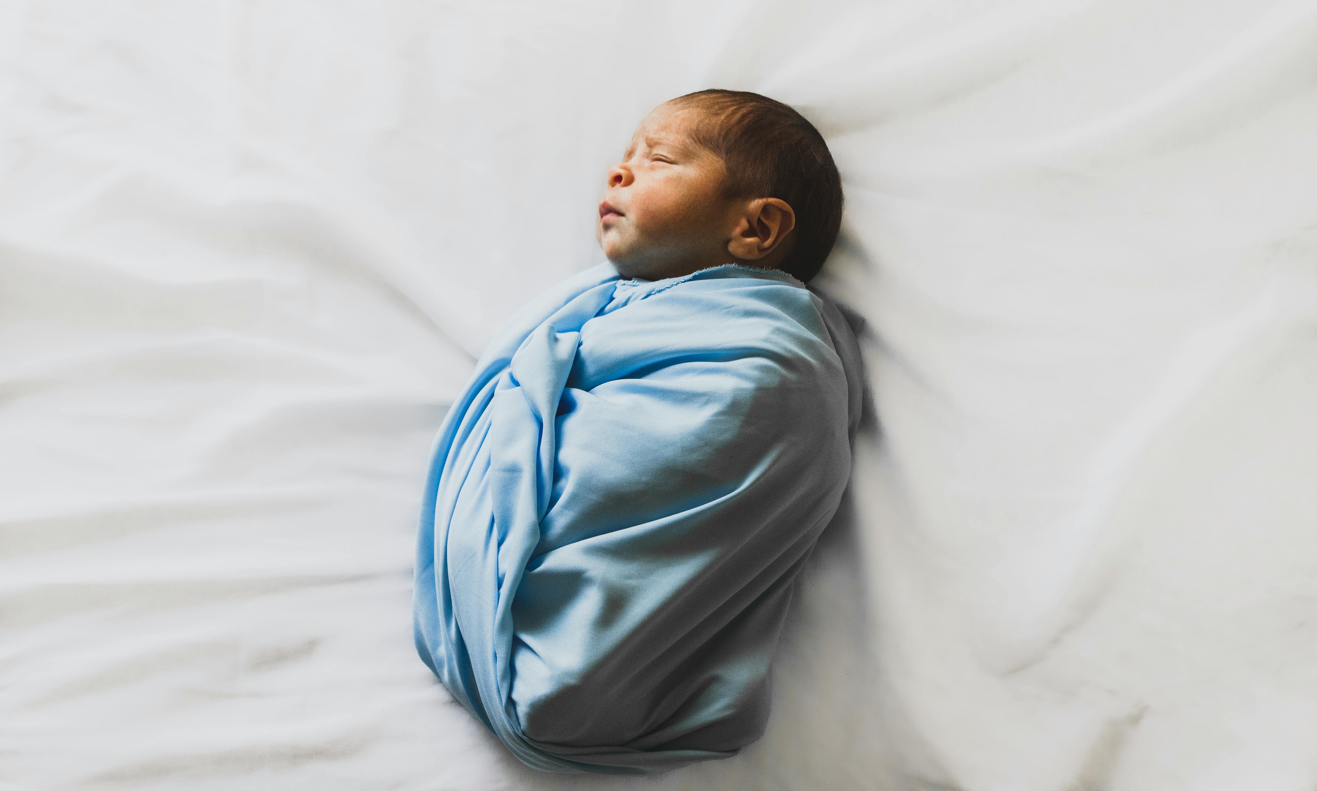 Newborn baby covered in blue blanket | Source: Pexels