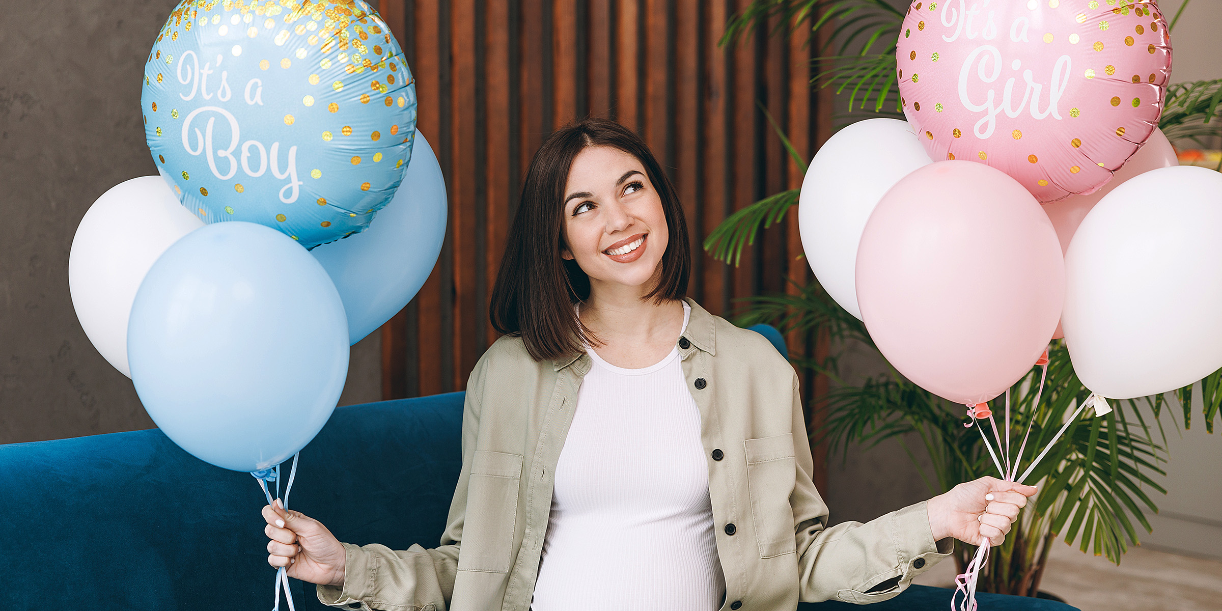 A happy woman holding balloons at a gender reveal party | Source: Shutterstock