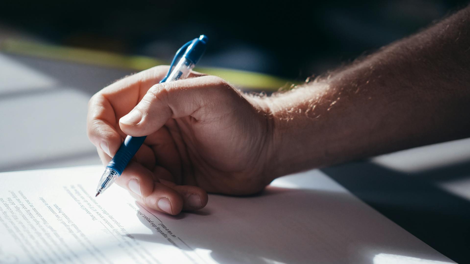 A man signing papers | Source: Pexels