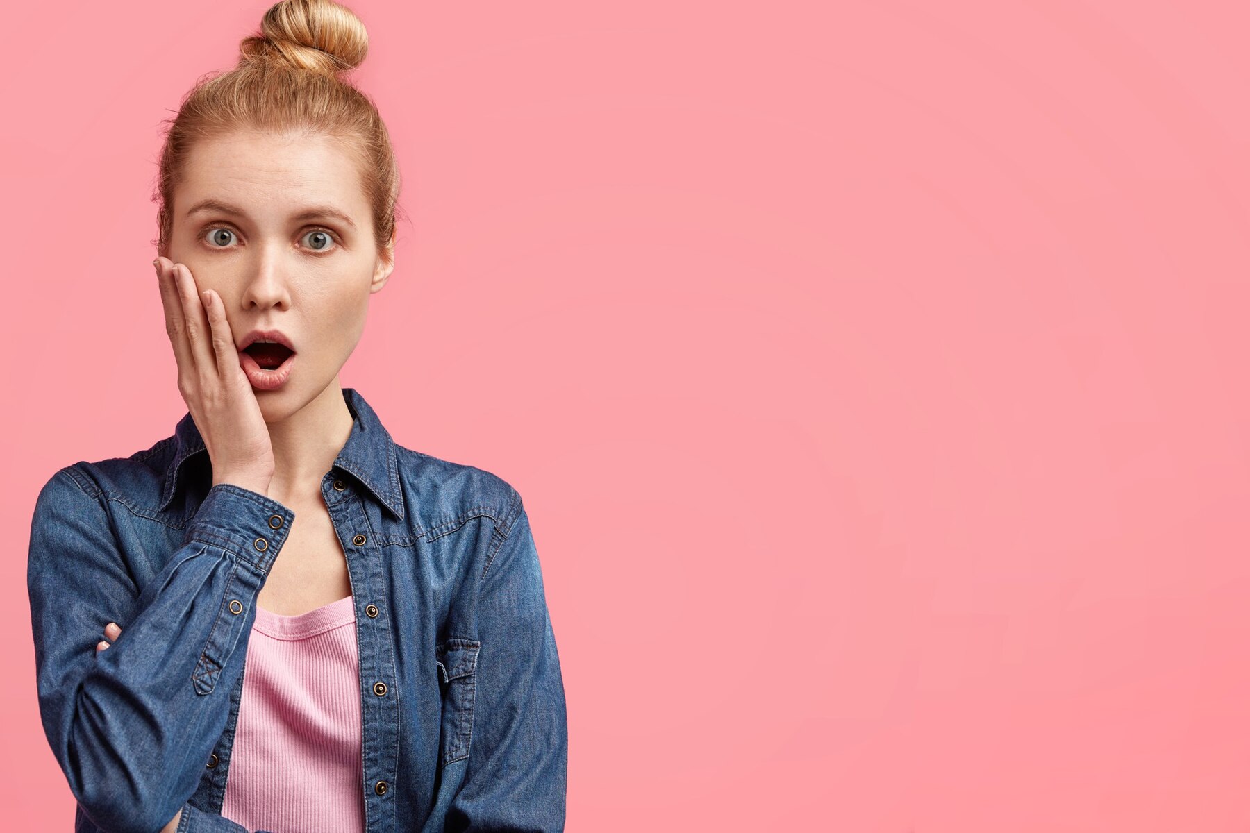 A shocked woman in a denim jacket | Source: Freepik