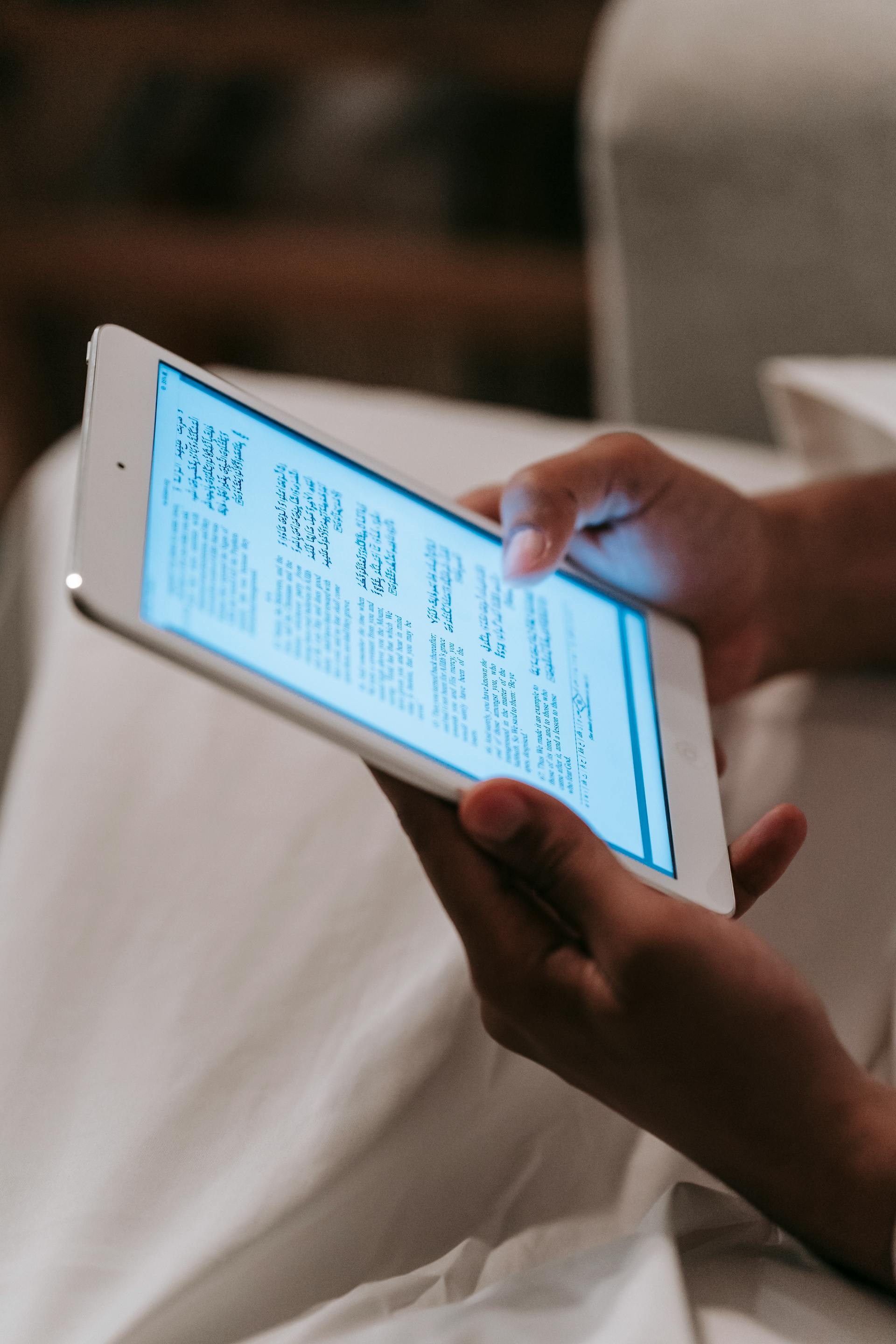 A person holding and looking at a tablet with glowing screen | Source: Pexels