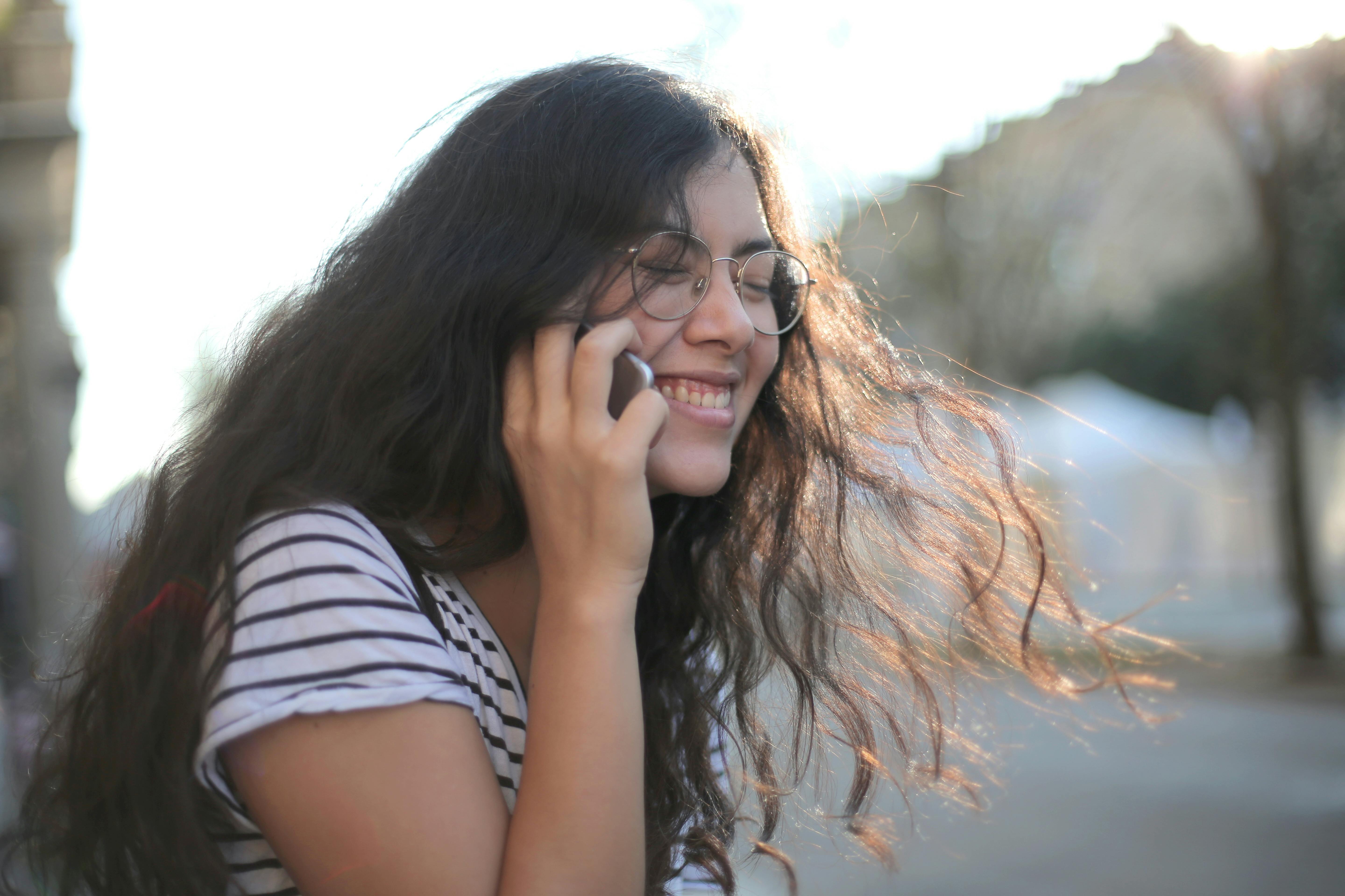 A girl laughing while on a call | Source: Pexels