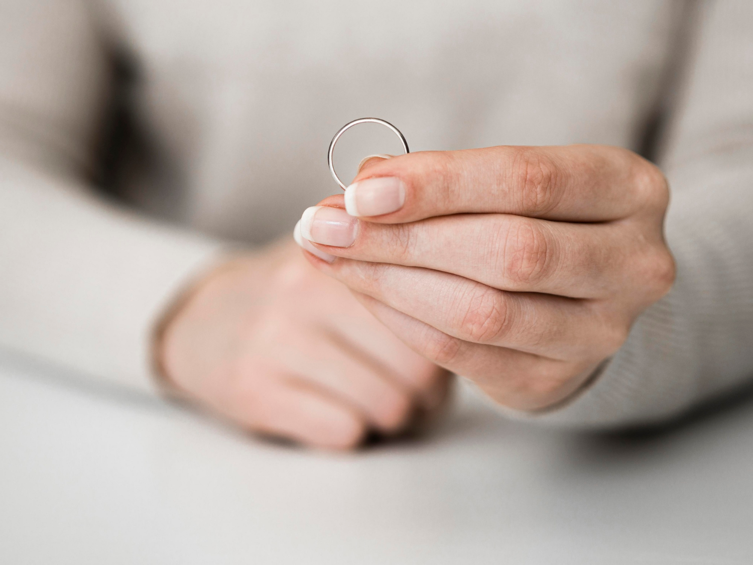 A woman holding a wedding ring | Source: Freepik