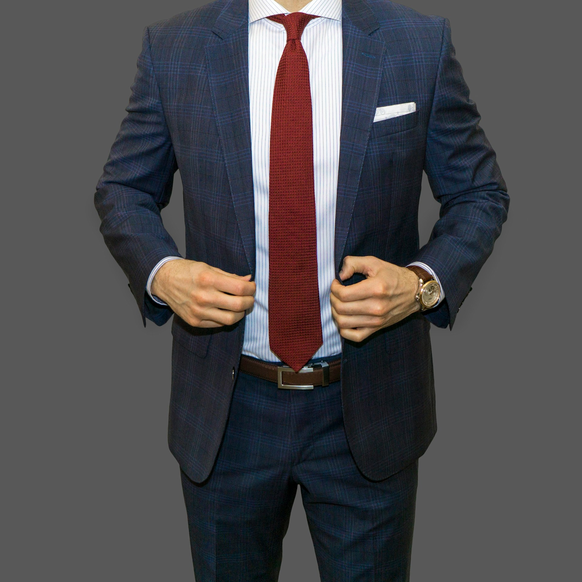 Cropped shot of a man in a dark suit | Source: Unsplash
