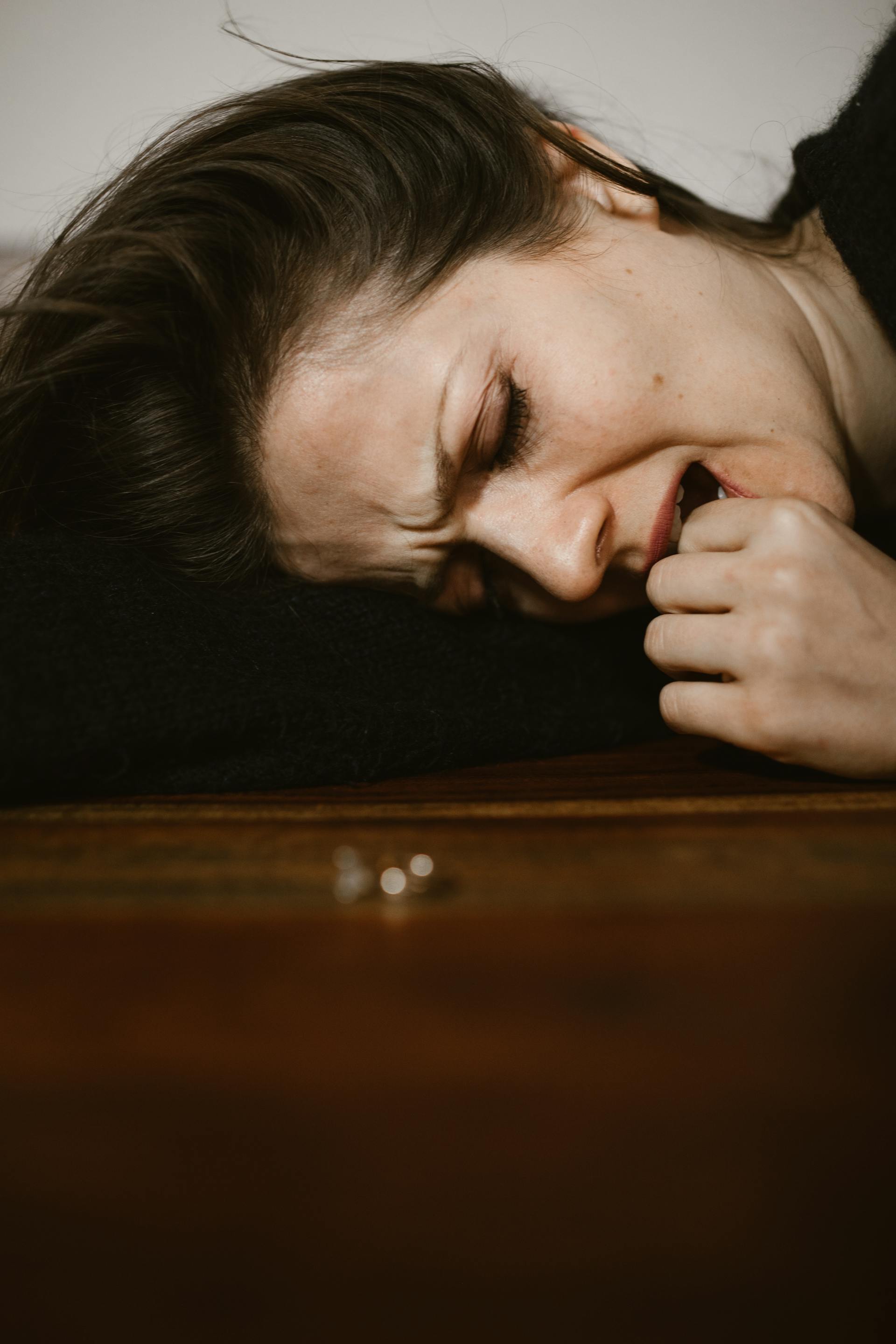 An emotional woman lying on a floor | Source: Pexels