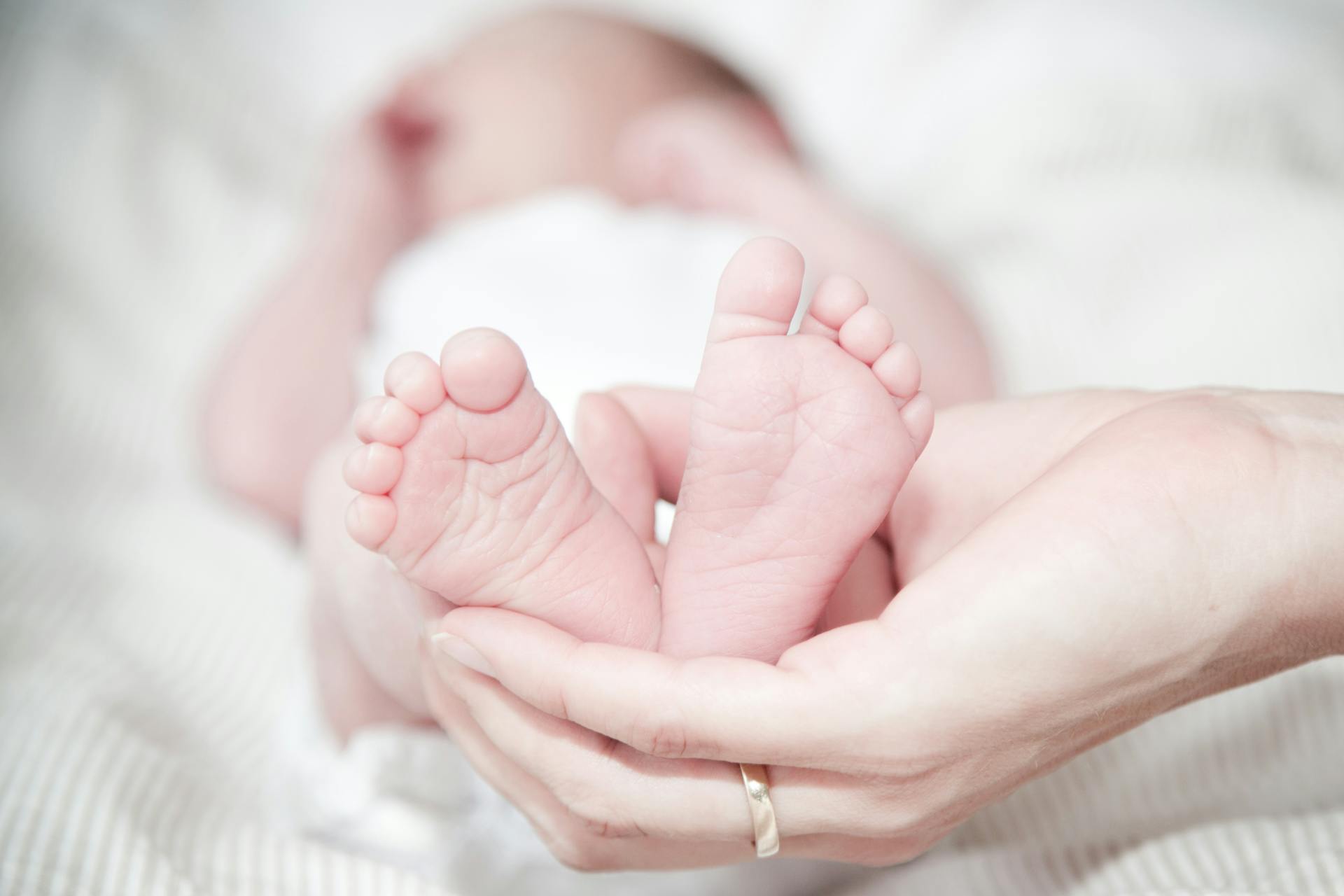 A woman holding her baby's feet | Source: Pexels