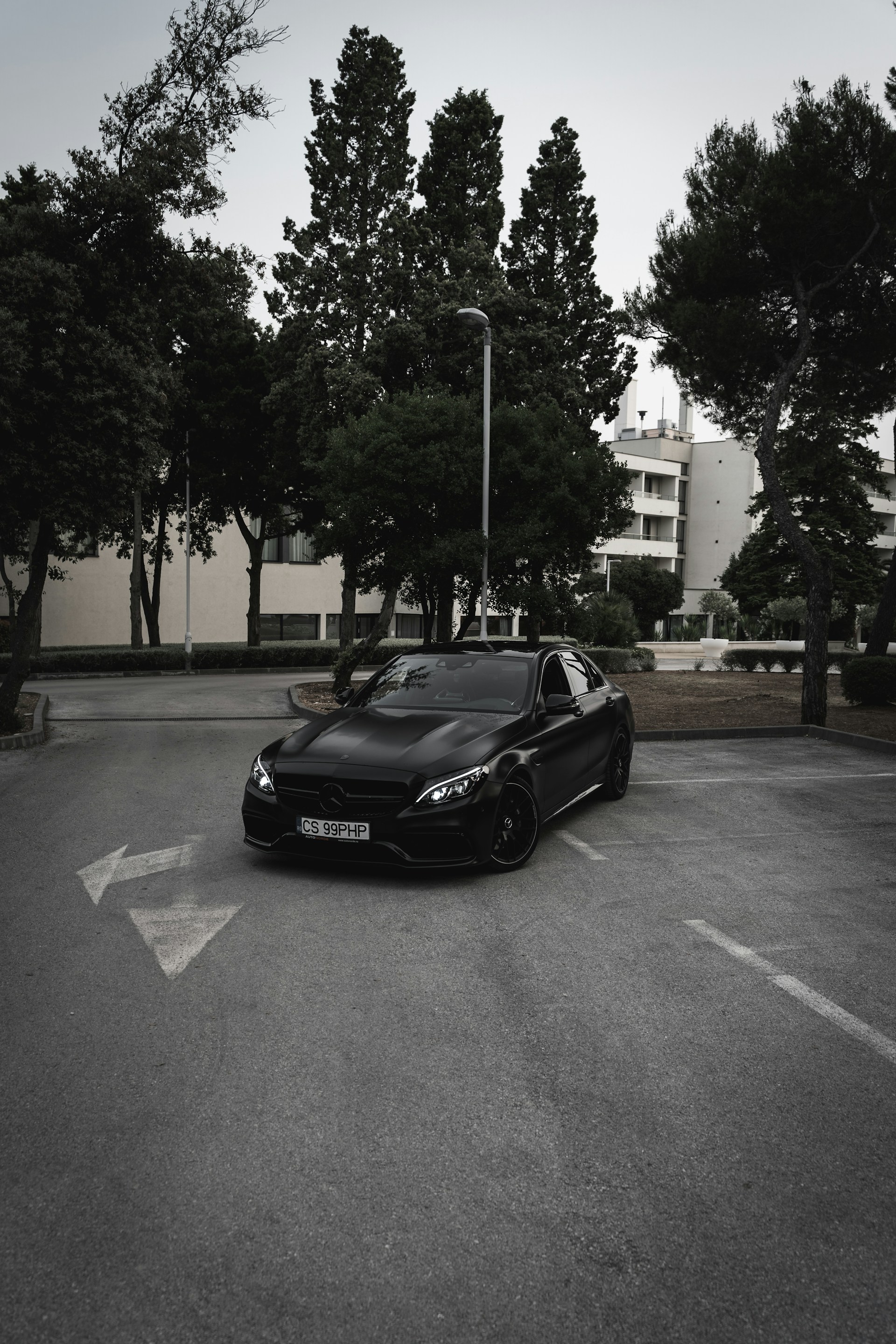A black car parked in the lot outside a building | Source: Unsplash