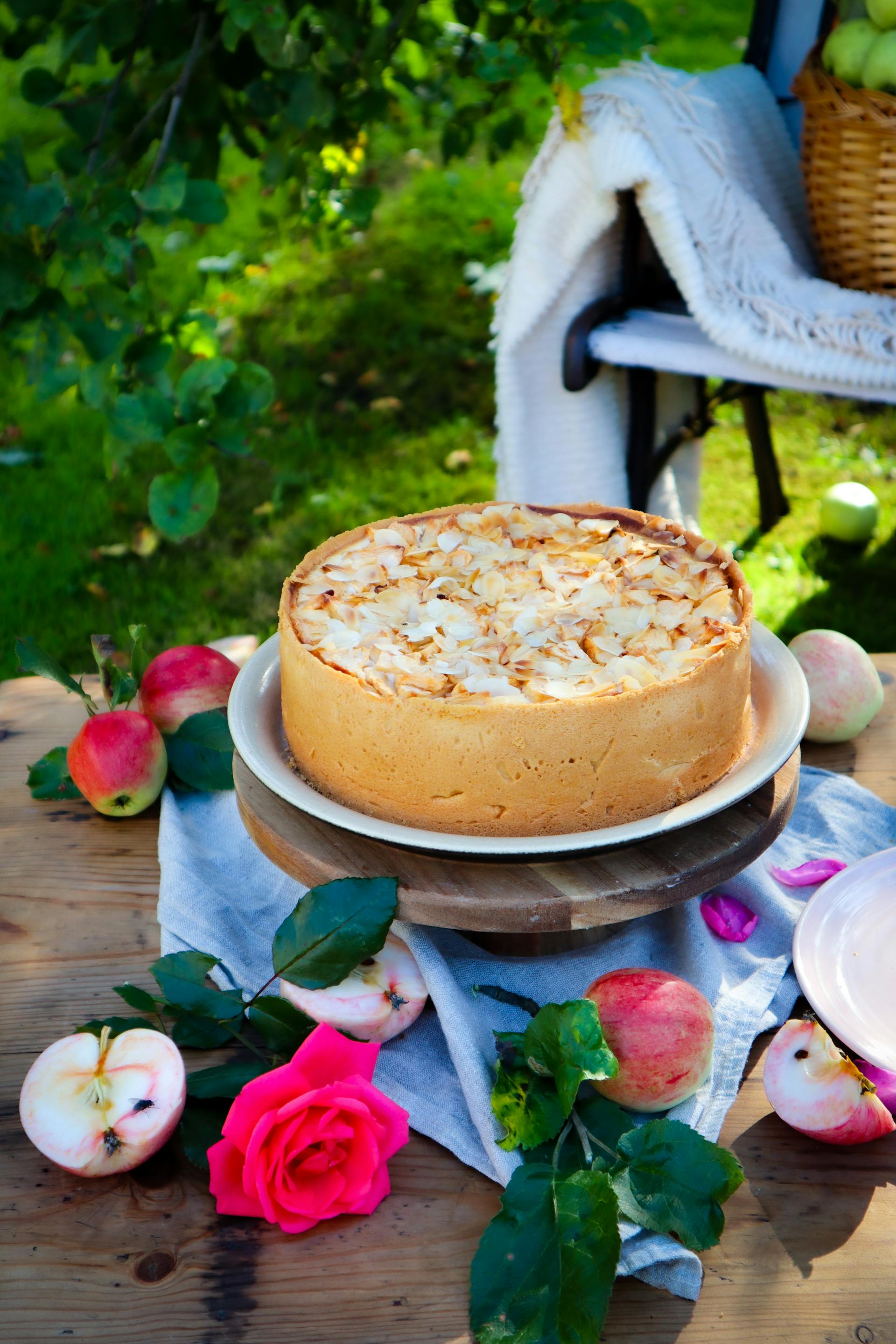 A crispy shortbread cheesecake topped with apples served on a table outdoors | Source: Pexels