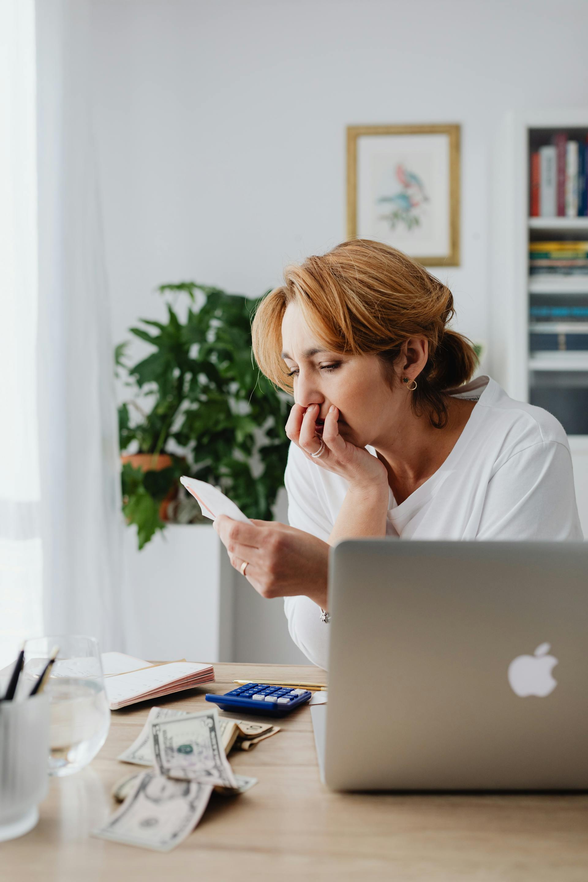 A thoughtful woman sitting at a desk | Source: Pexels