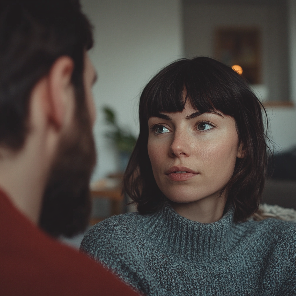 A serious woman talking to a man in her living room | Source: Midjourney