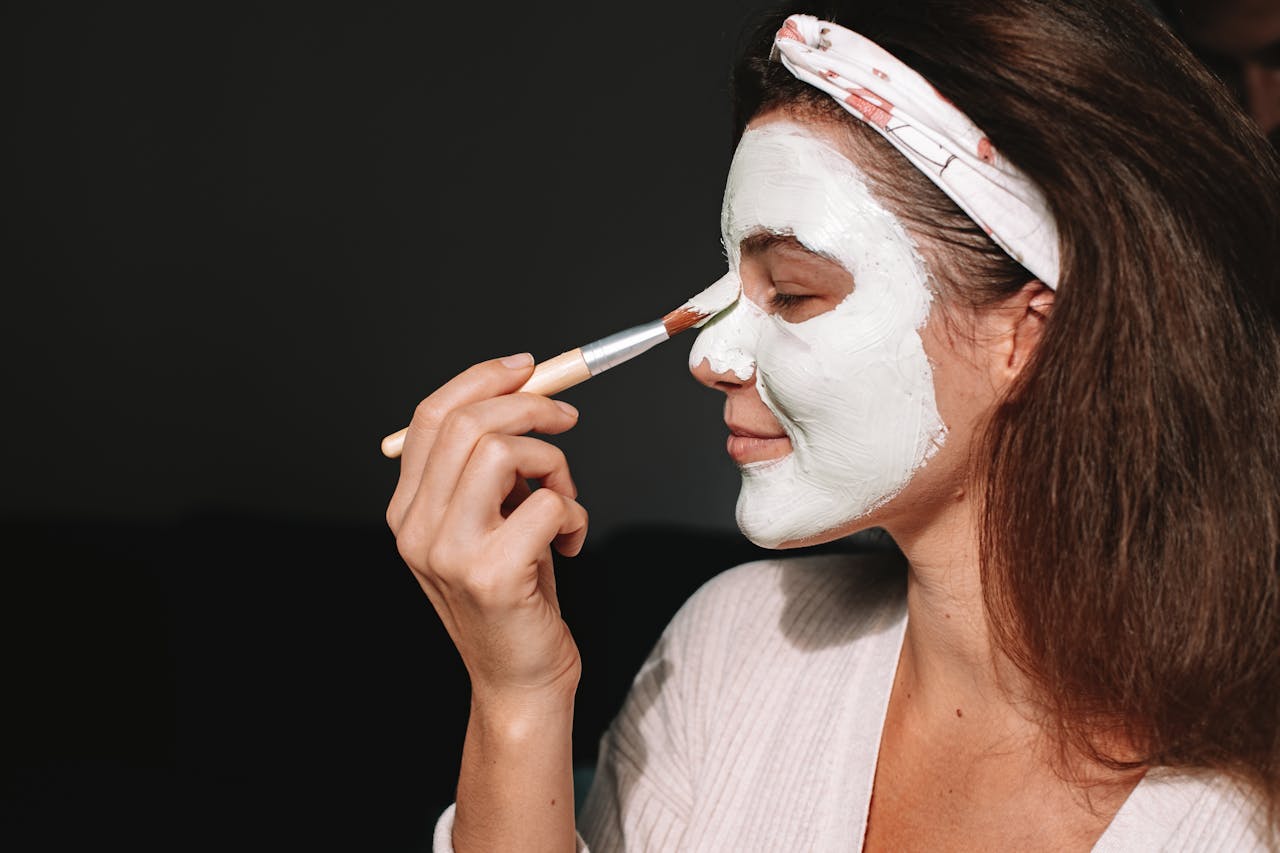 A woman applying a face mask | Source: Pexels