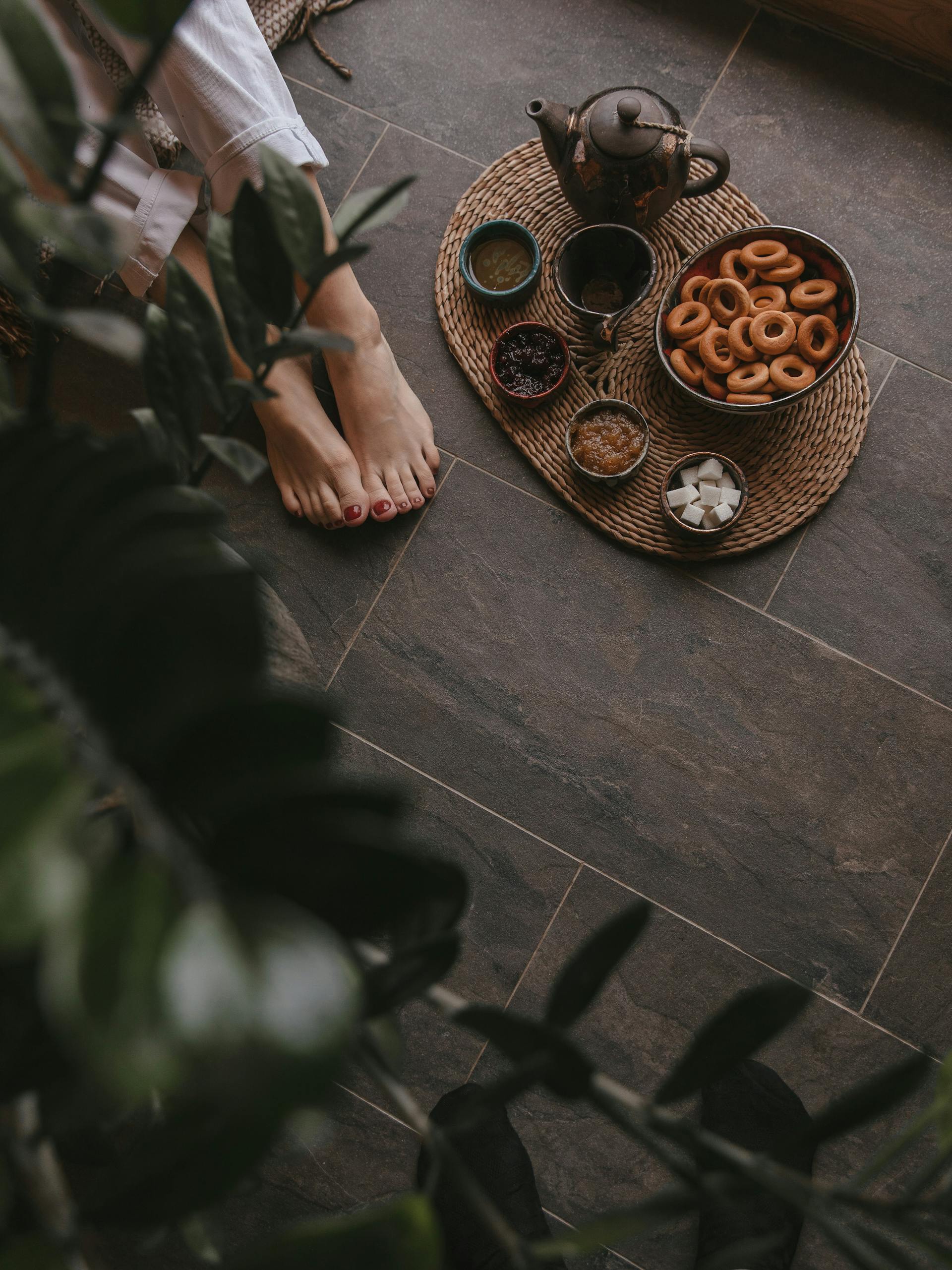 Tea and food placed near a person's feet | Source: Pexels