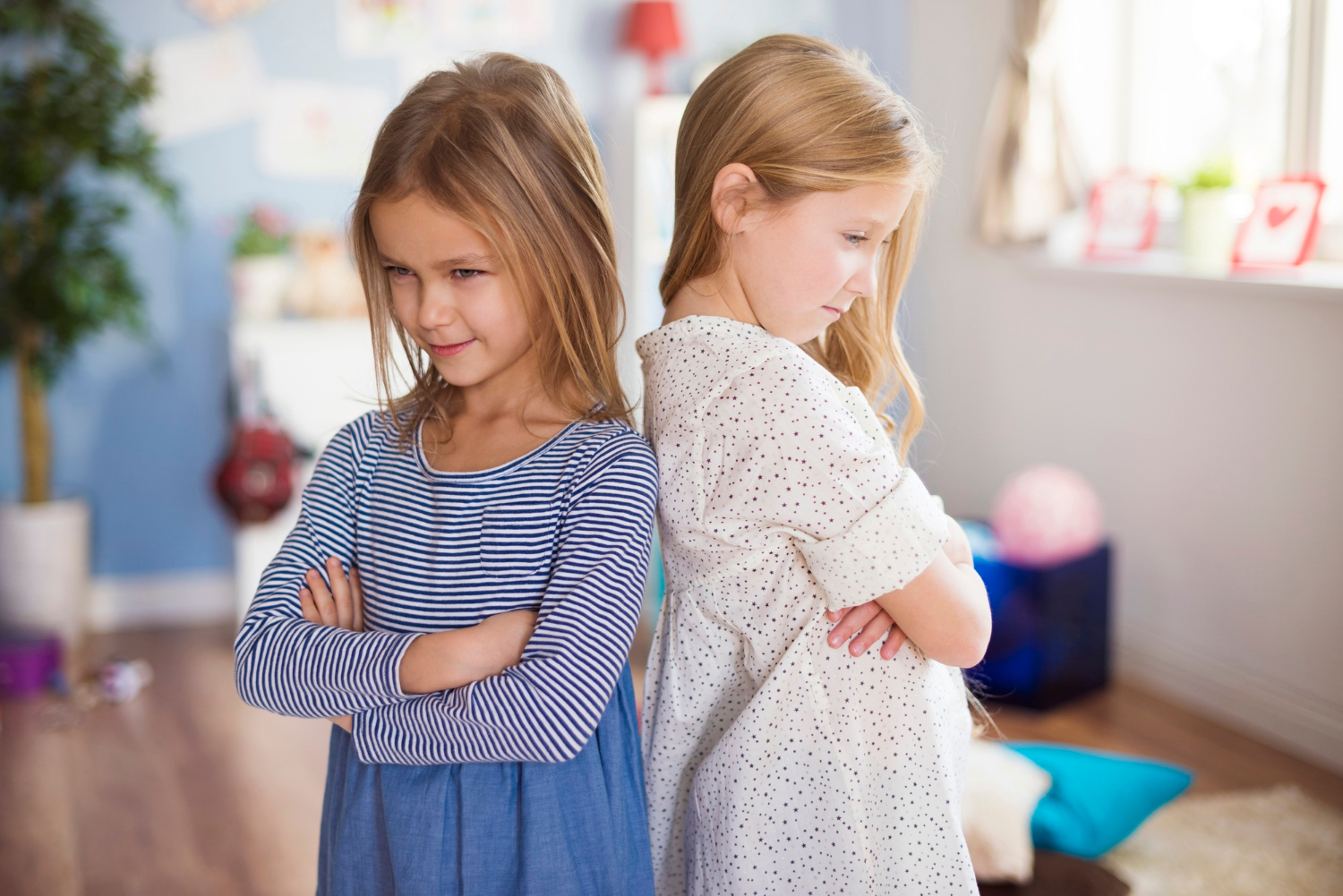 Two girls standing with their arms crossed | Source: Freepik